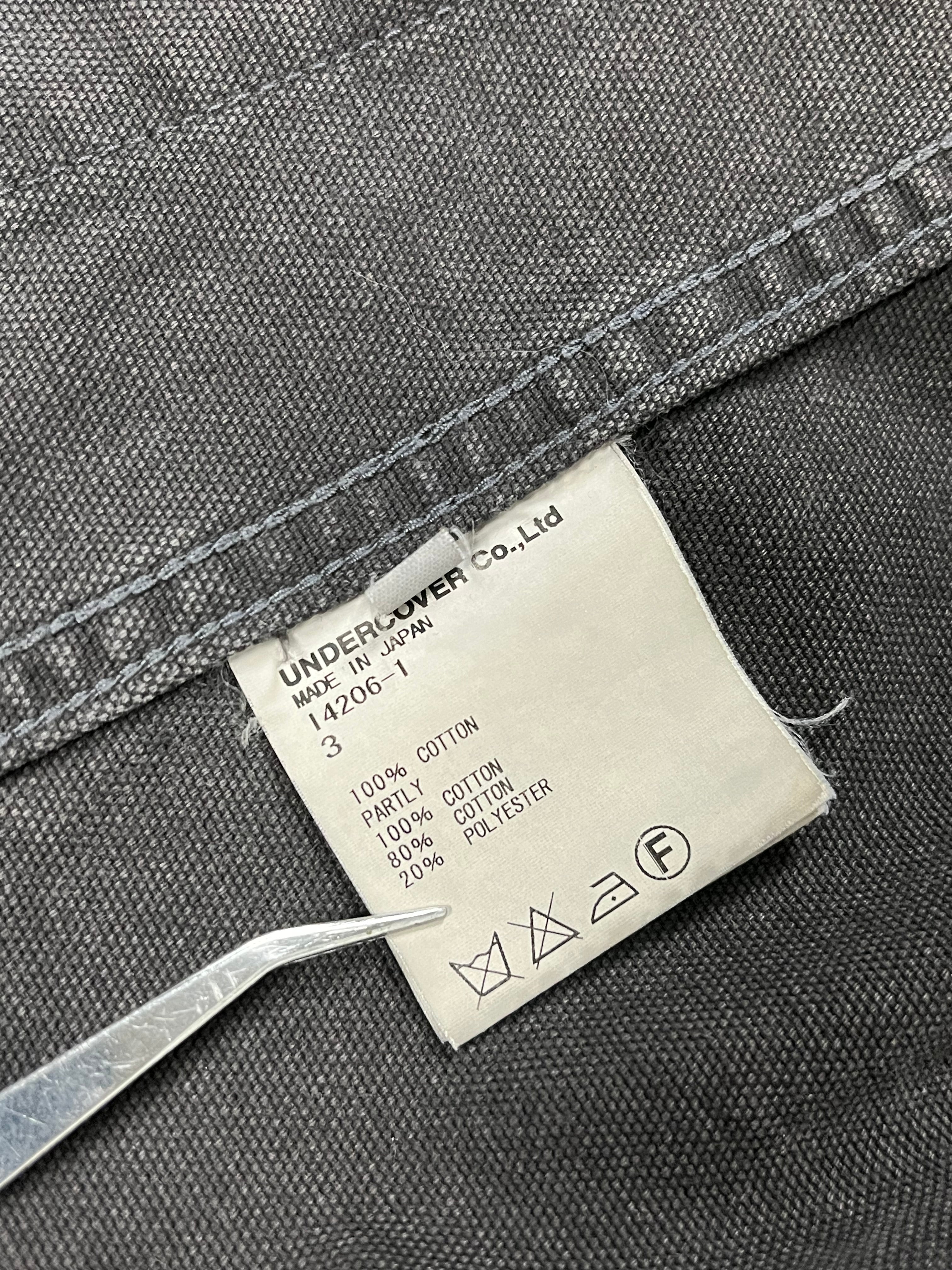 Undercover SS12 “Openstrings” work jacket, black lightweight jacket with open string details, casual streetwear style.