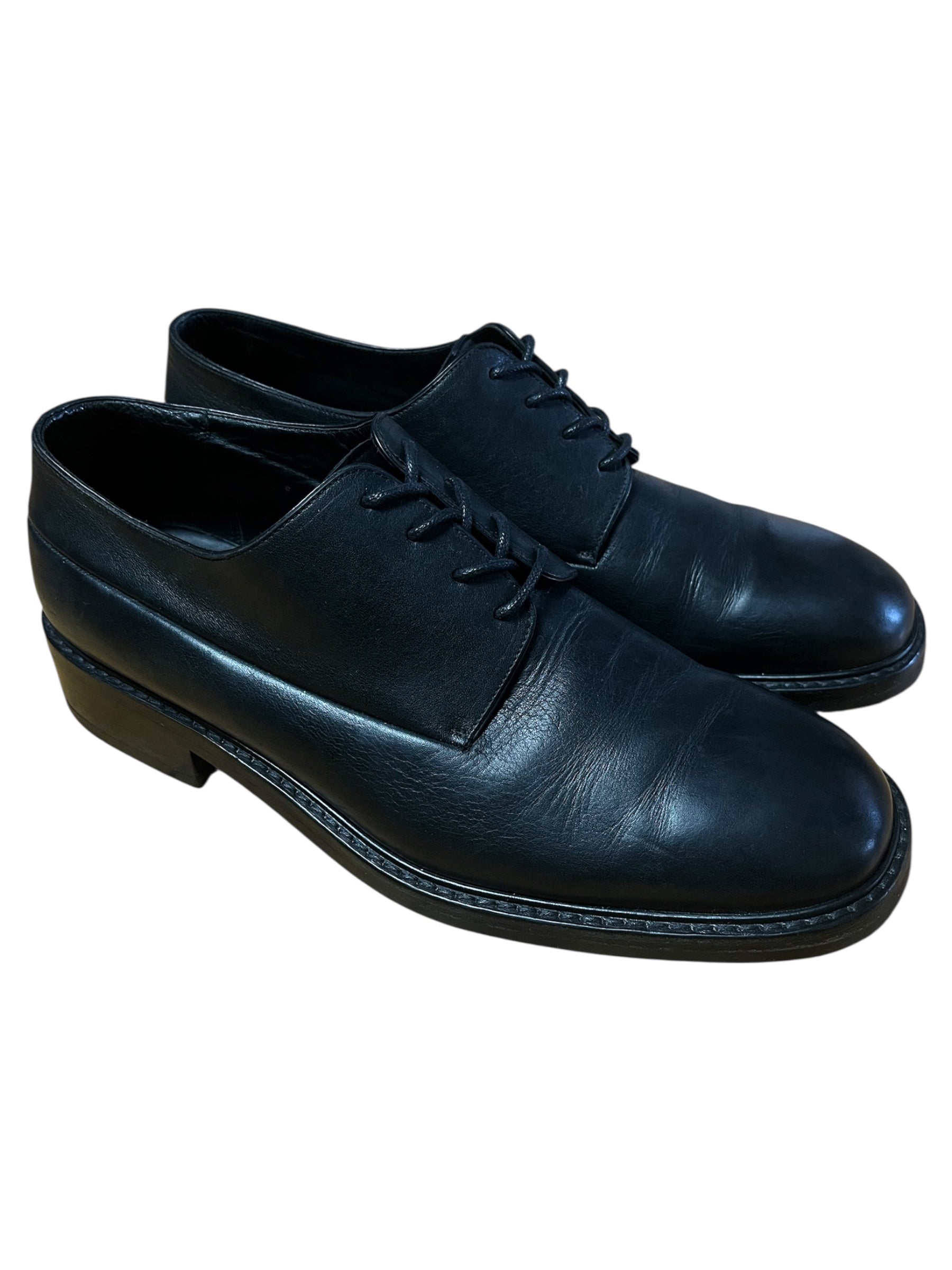 Dior black leather derby shoes with polished finish, classic lace-up design, and sleek silhouette.