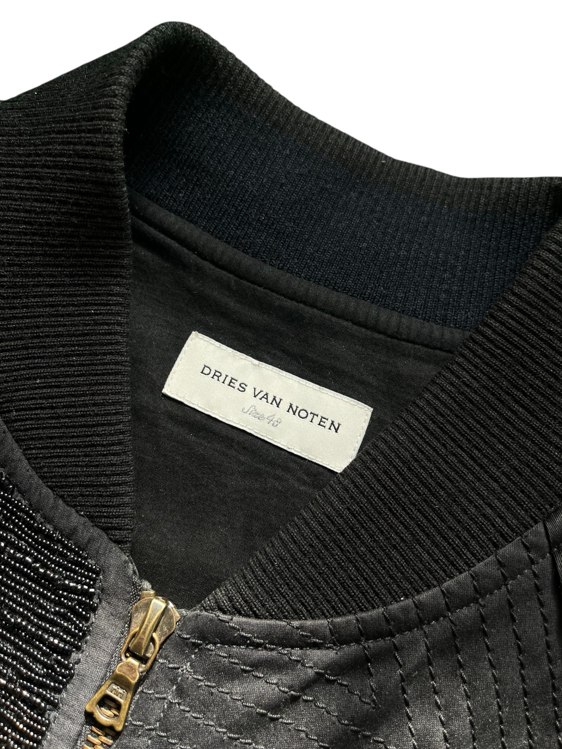 Dries Van Noten SS17 patchwork bomber jacket with mixed fabric panels and ribbed cuffs, displayed on a hanger.
