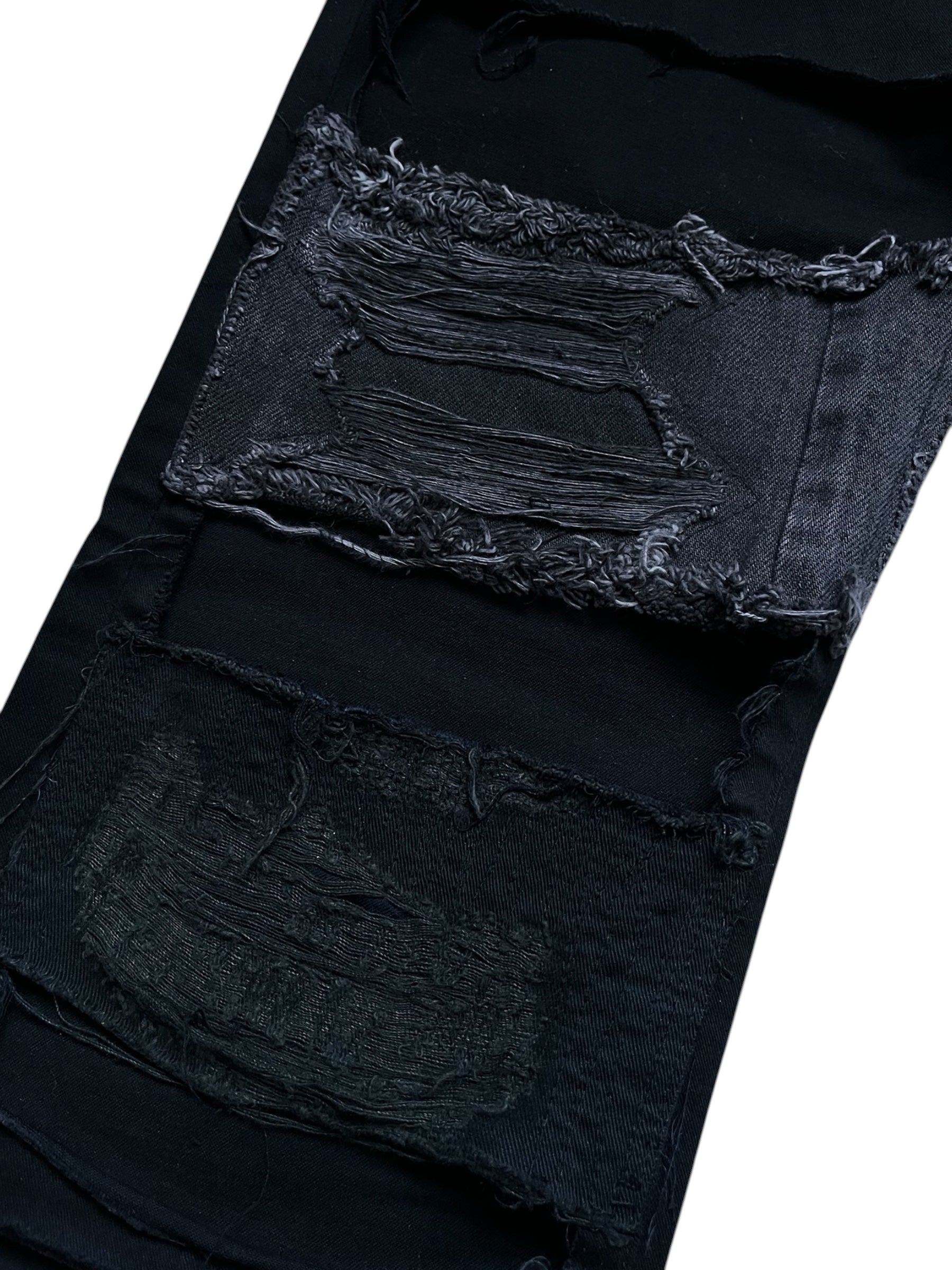 Undercover SS23 Bright Side of the Dark Side SCAB distressed denim jeans with shredded and worn details.