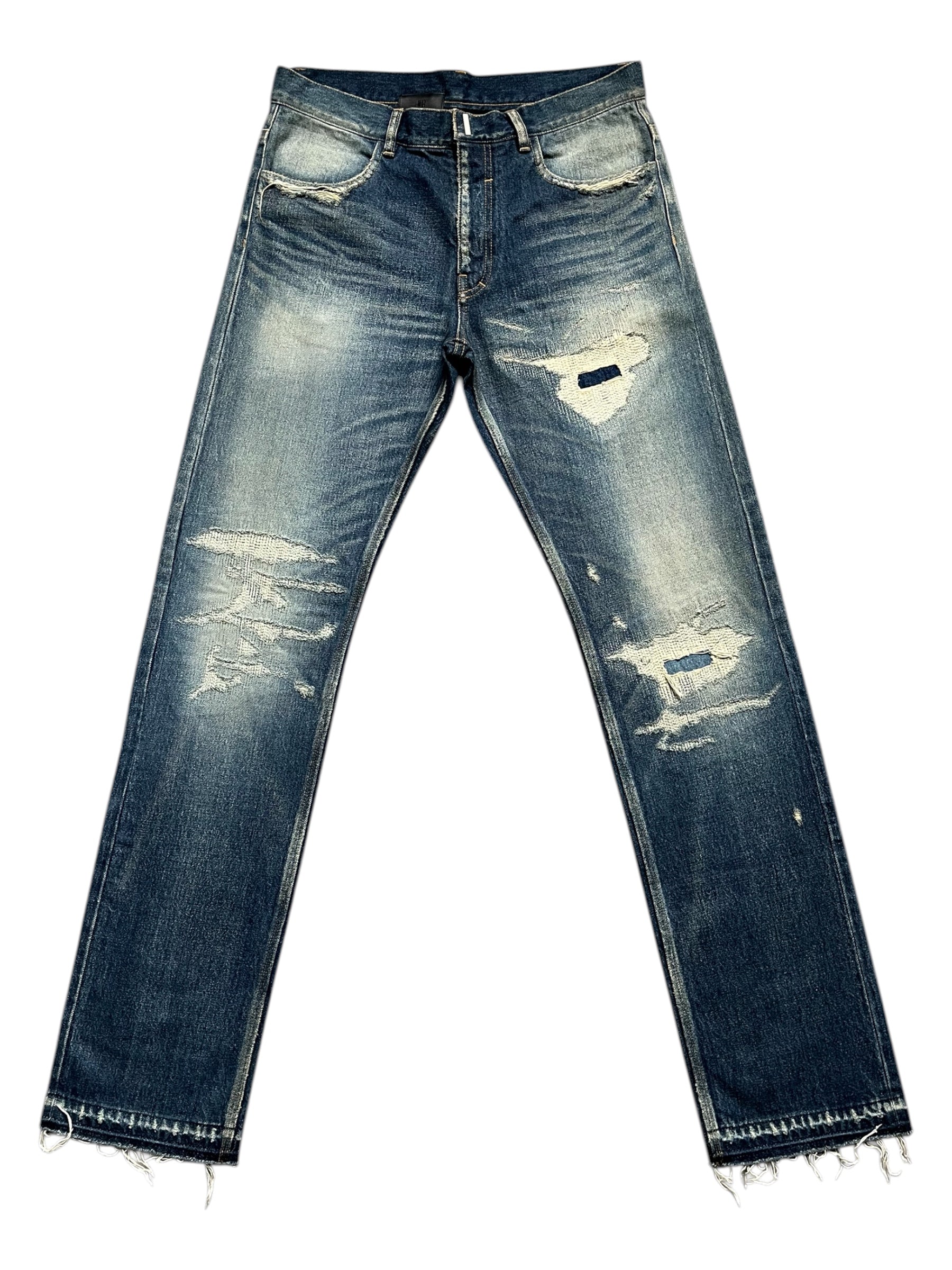 Givenchy FW23 distressed boro blue denim pants with ripped details and a relaxed fit, displayed on a neutral background.