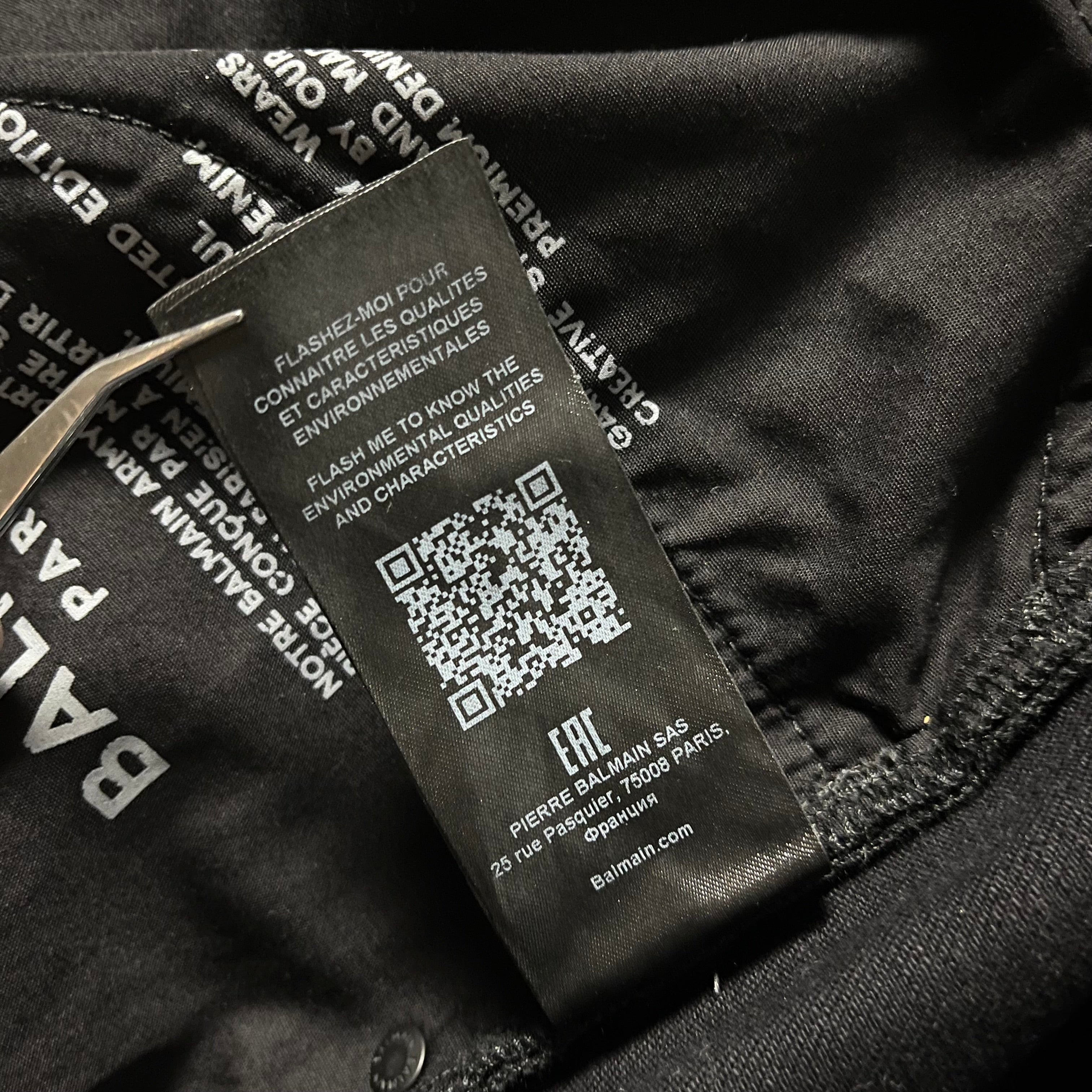 Balmain AW23 limited edition waxed denim pants showing a close-up of textured, stylish denim fabric with subtle branding details.