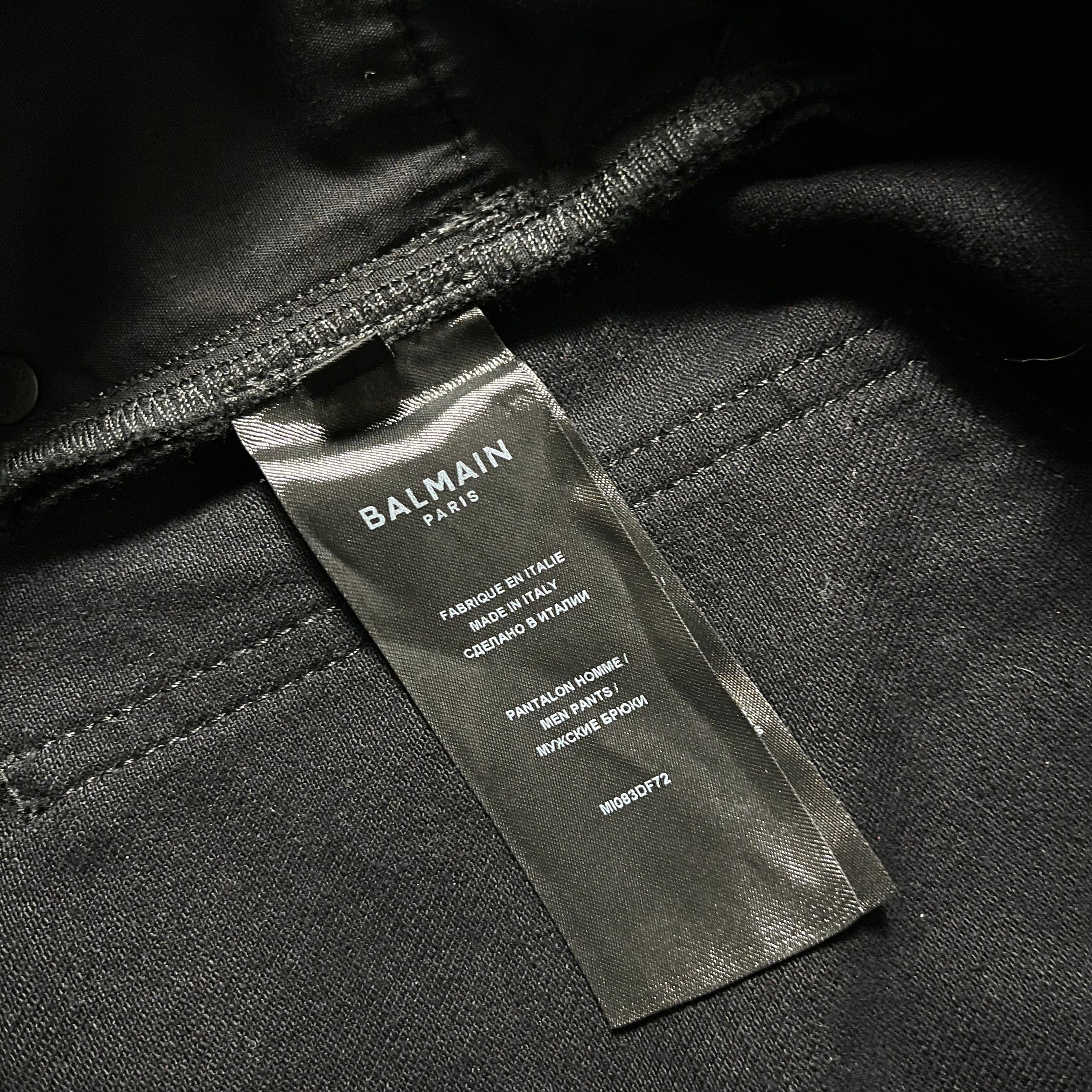 Balmain AW23 limited edition waxed denim pants with a fitted design and stylish detailing, displayed on a neutral background.