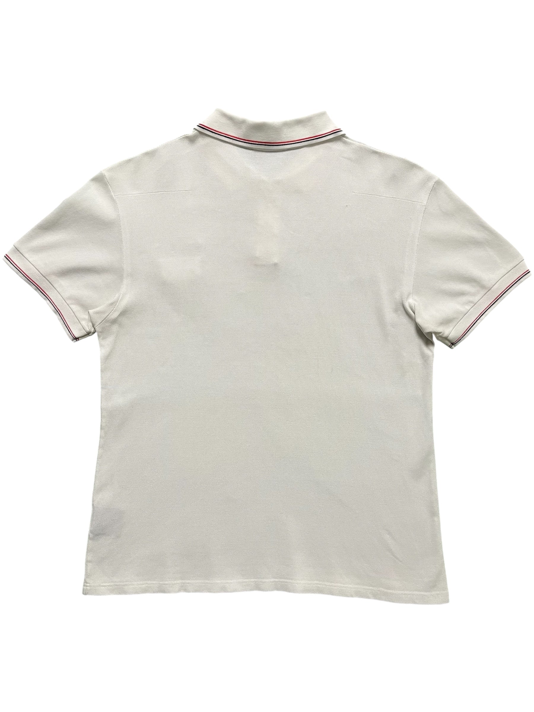 Dior SS07 Patch Polo shirt in navy with embroidered patches, classic polo collar, and short sleeves, displayed on a hanger.