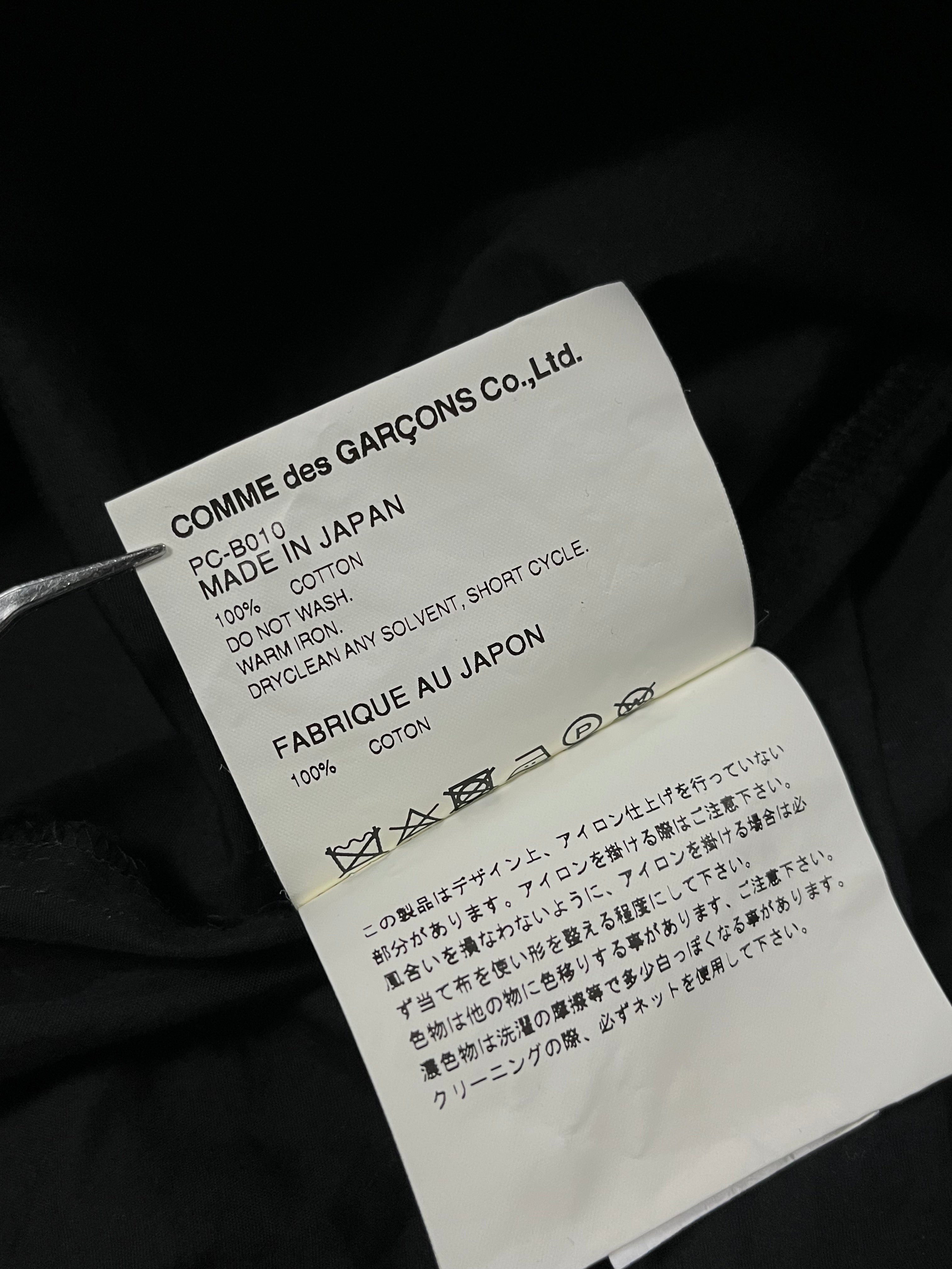 Comme des Garçons Homme Plus SS19 paneled shirt showing black and white fabric panels and classic collar detail.