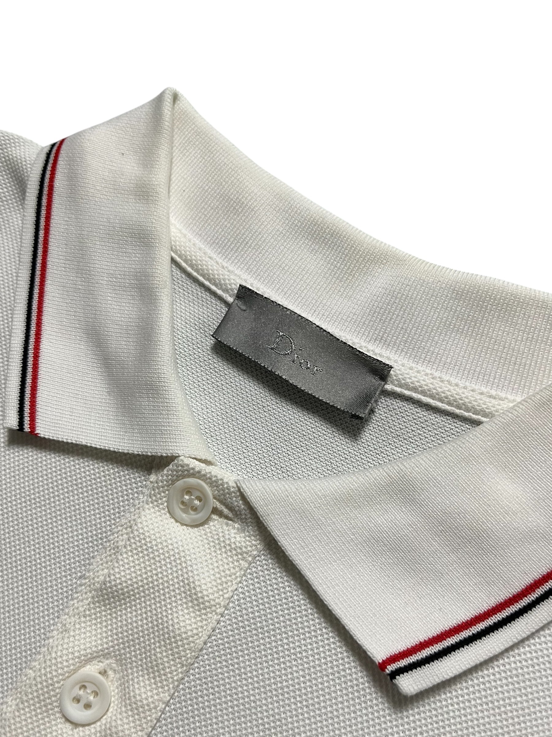 Dior SS07 Patch Polo shirt in navy with embroidered patches, displayed flat on white background.