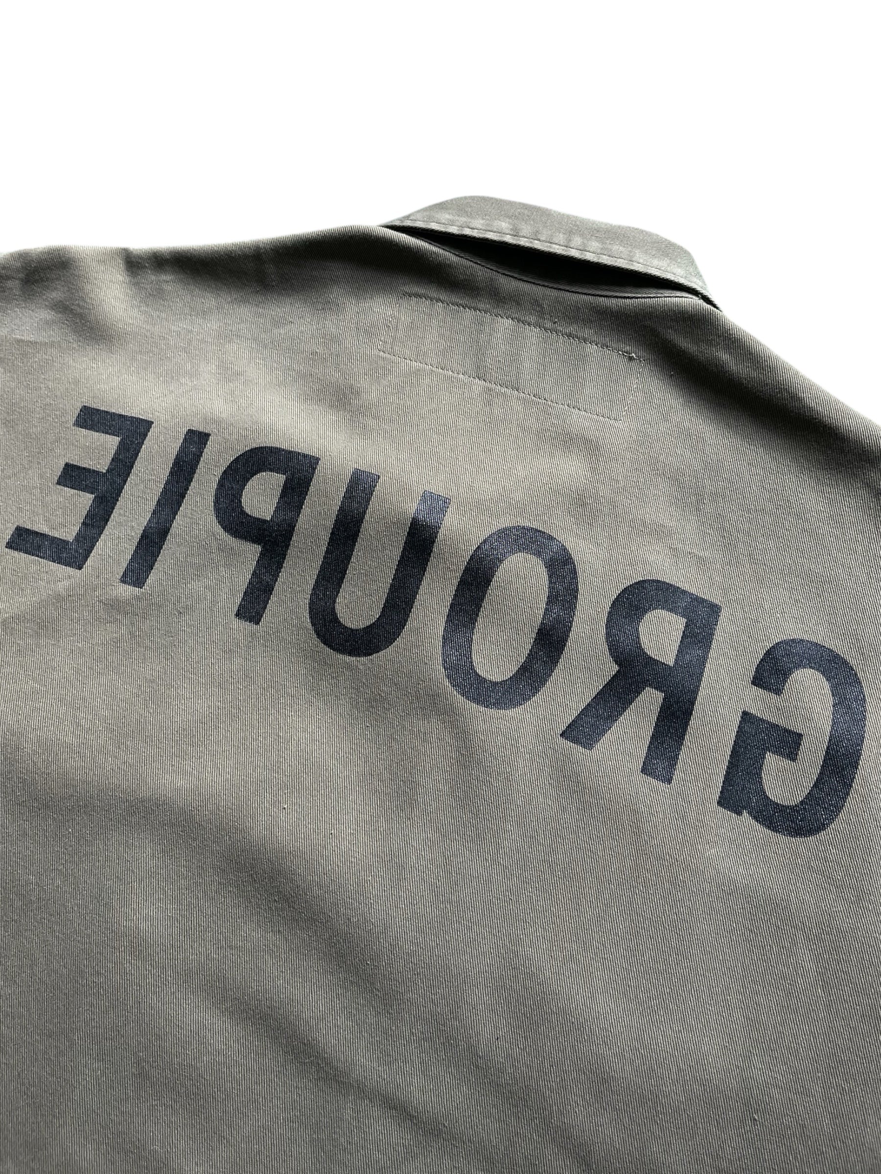 Undercover SS99 Relief Groupie Military Shirt with camouflage pattern and military-inspired design, displayed on a hanger.