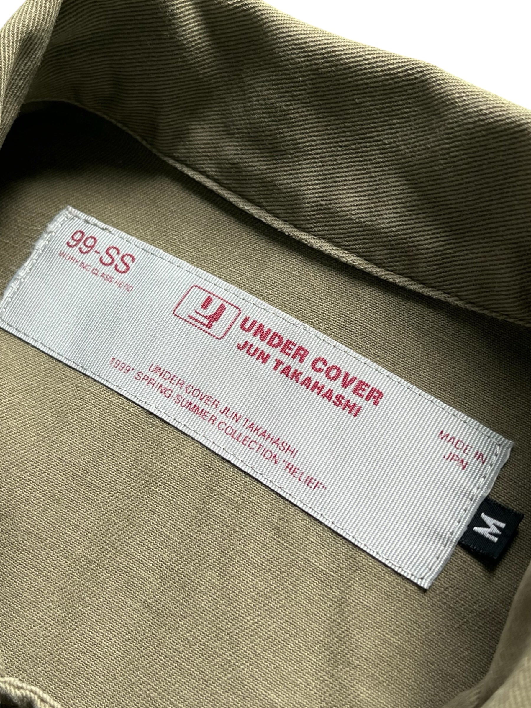 Undercover SS99 Relief Groupie Military Shirt displayed flat showing its camouflage pattern and military-inspired design.