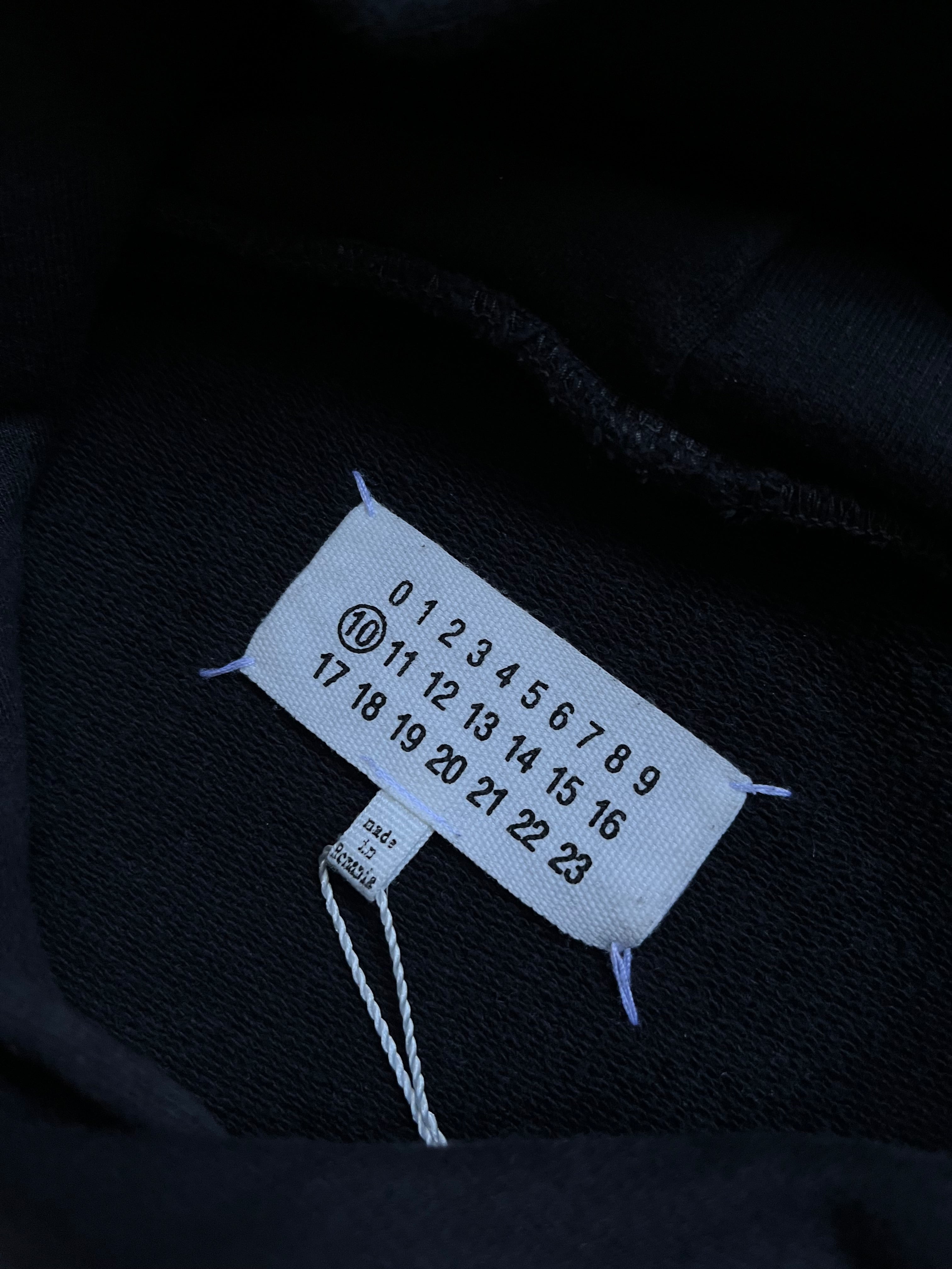 Maison Margiela SS22 Distorted Logo Hoodie showing the front with a bold, twisted logo design on soft cotton fabric.