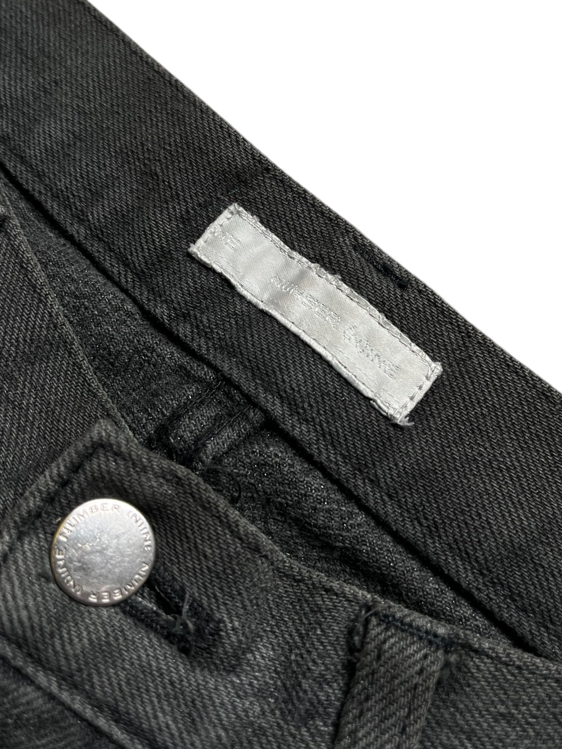 Number (N)ine AW01 "Standards" grey faded denim pants displayed on a hanger, showcasing the relaxed fit and distressed texture.