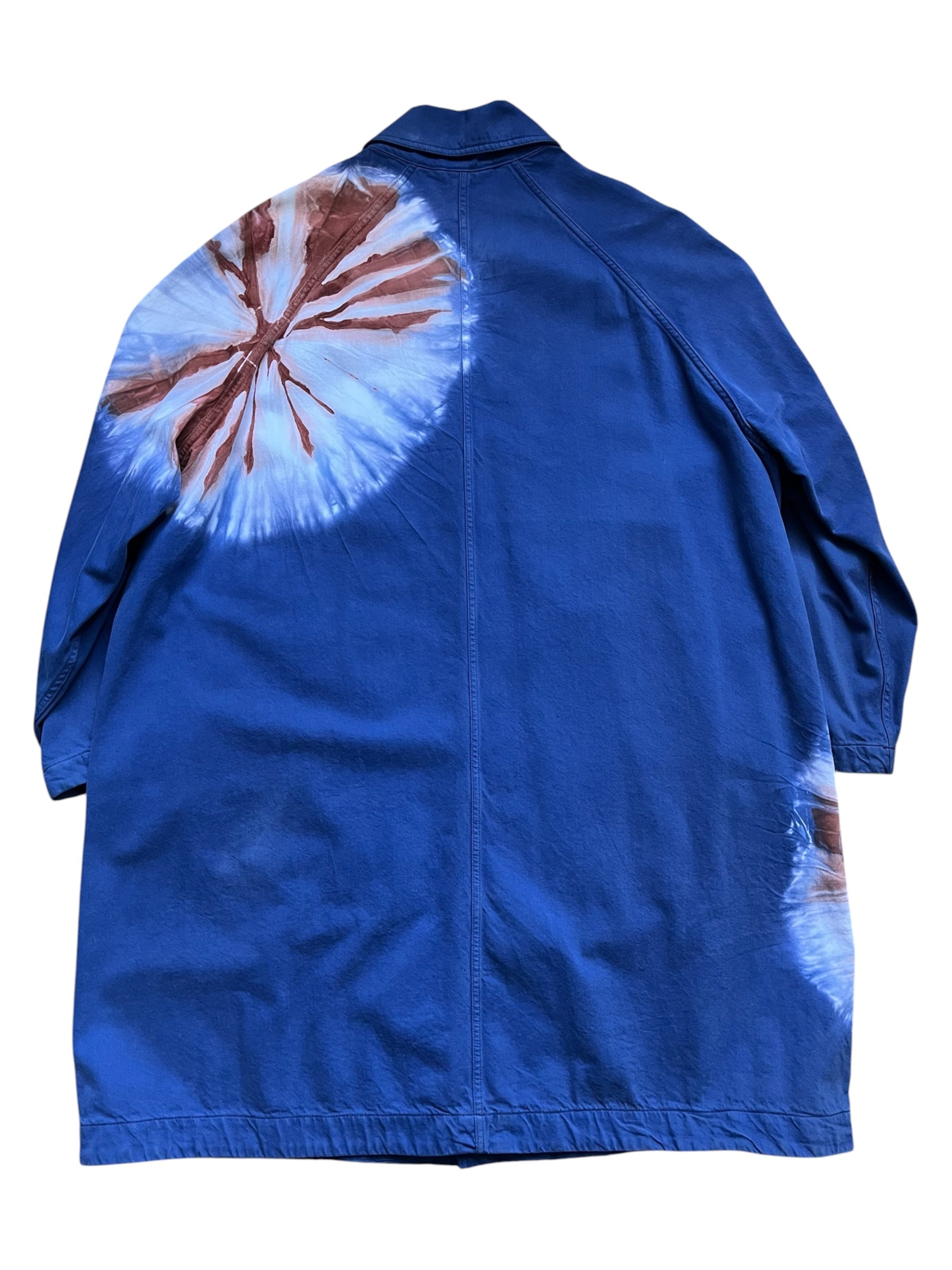 Raf Simons SS19 Calvin Klein 205w39nyc tie-dye overcoat hanging on a clothing rack, showcasing its vibrant pattern and stylish design.
