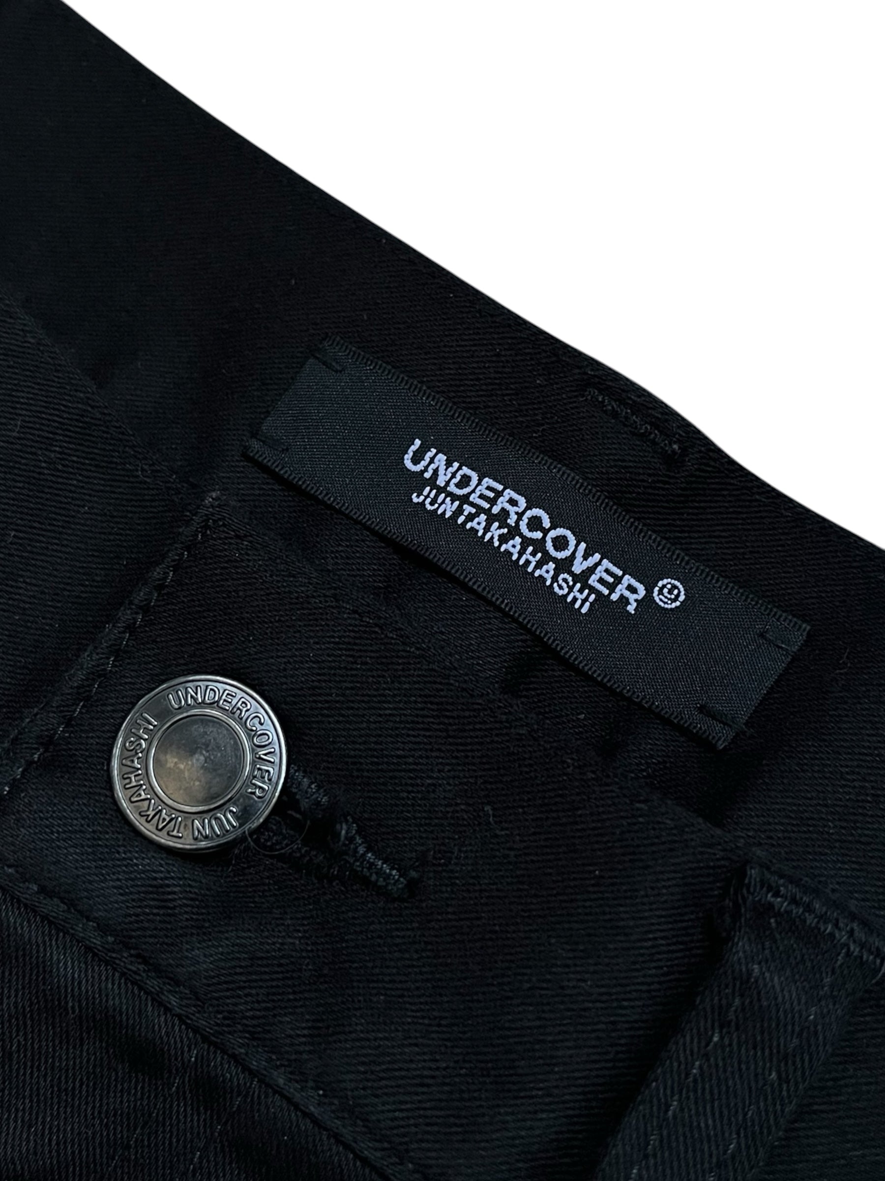 Undercover SS23 Bright Side of the Dark Side SCAB distressed denim jeans with ripped details and faded wash.