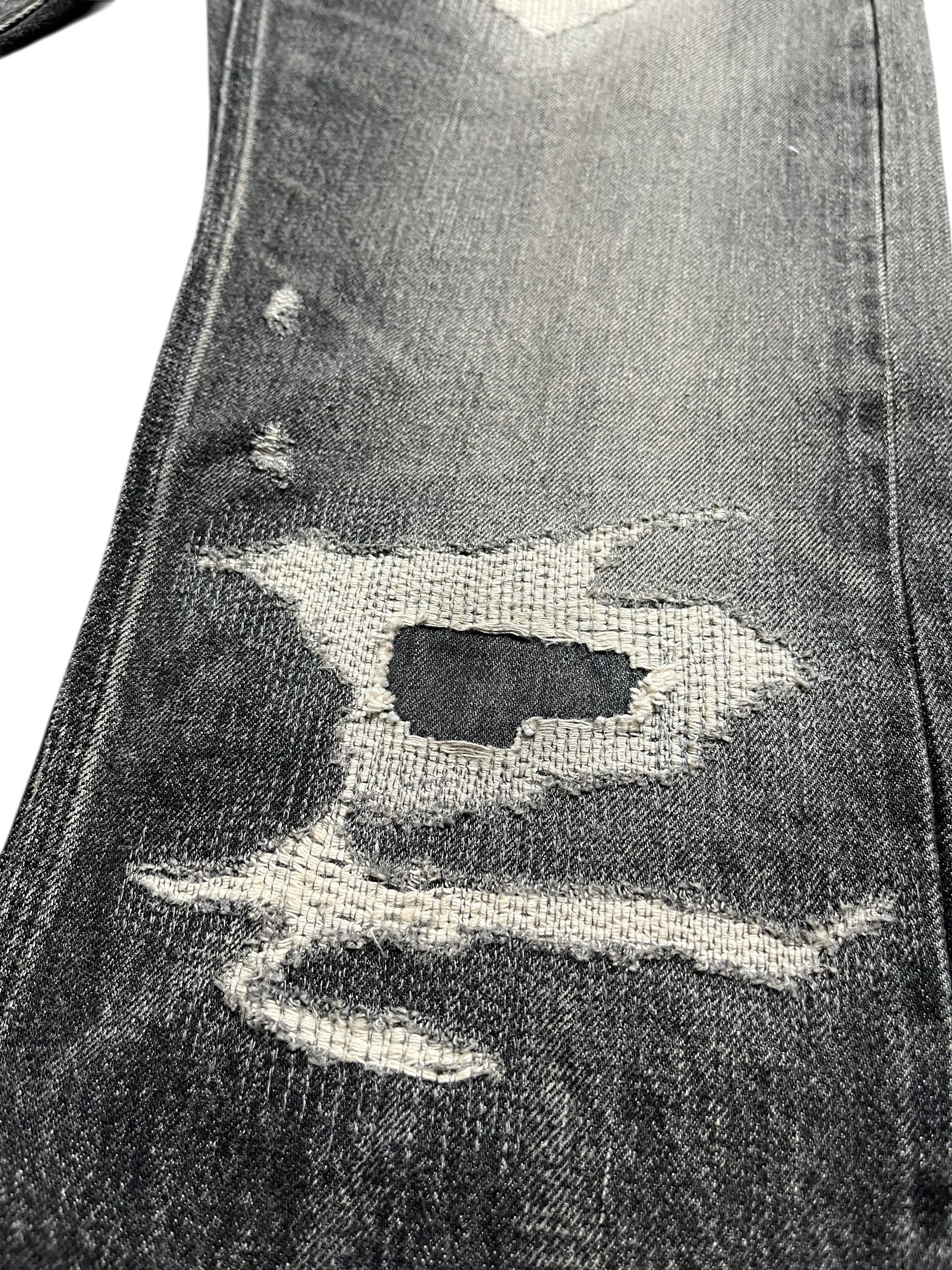 Givenchy FW23 distressed boro black denim pants with torn and rugged details, showcasing a stylish and edgy design.