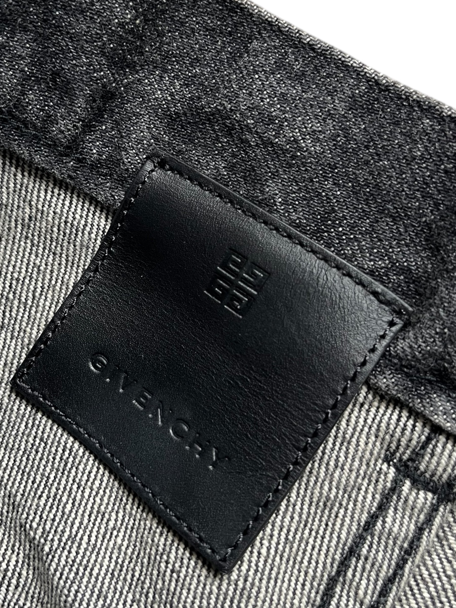 Givenchy FW23 distressed boro black denim pants, slim-fit with ripped details and raw hem, displayed on a neutral background.