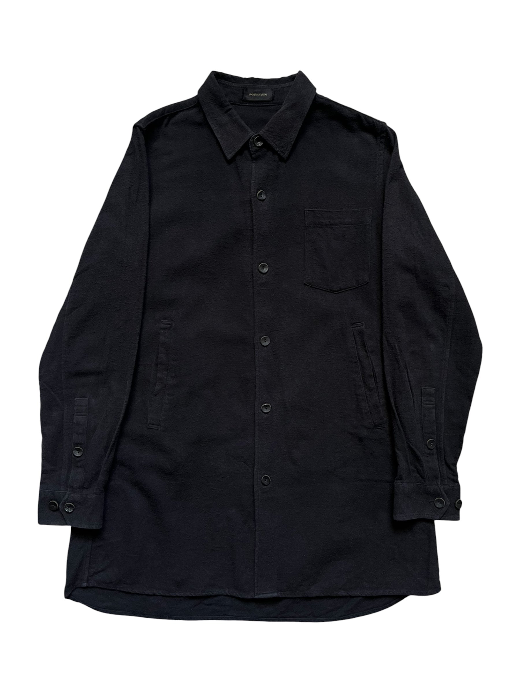 Undercover AW14 "Cold Blood" brushed cotton overshirt with a dark, textured fabric and button front, displayed on a hanger.
