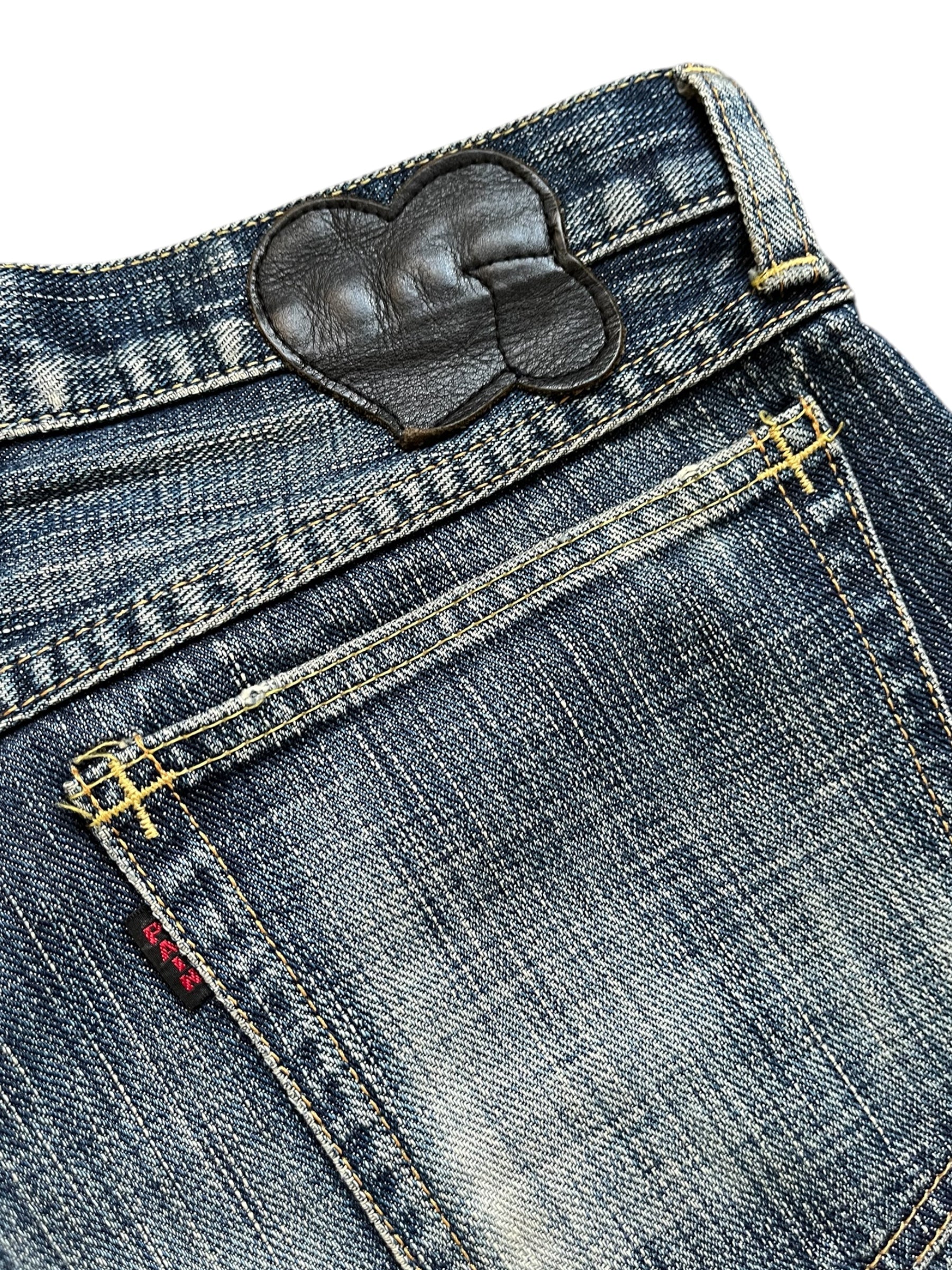 Distressed SS05 “Nightcrawler” denim pants by Number (N)ine featuring ripped details and a slim fit design.
