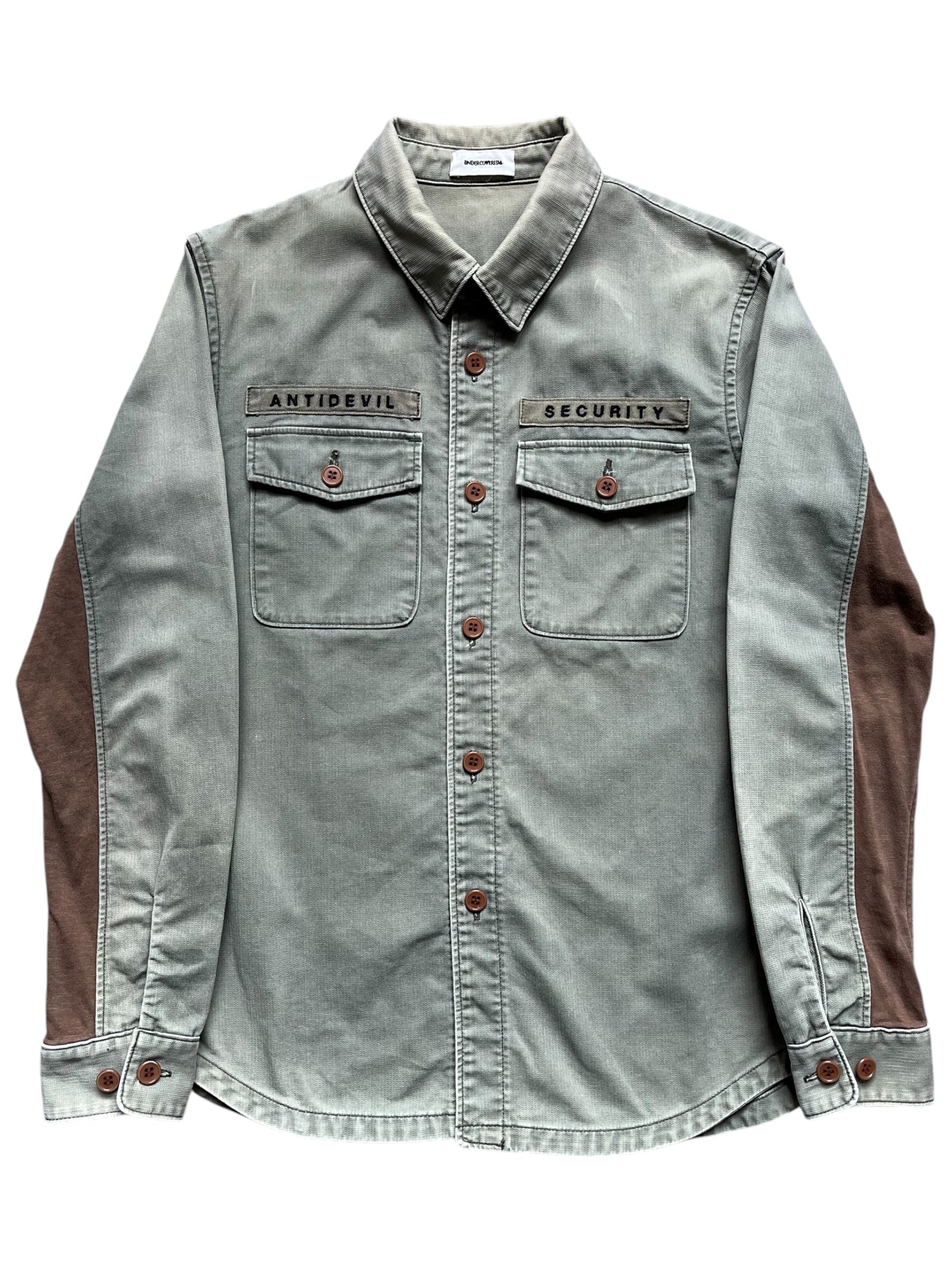 Undercover SS11 "Underman" Anti-Devil military shirt with camouflage pattern and tactical design, shown on a hanger.