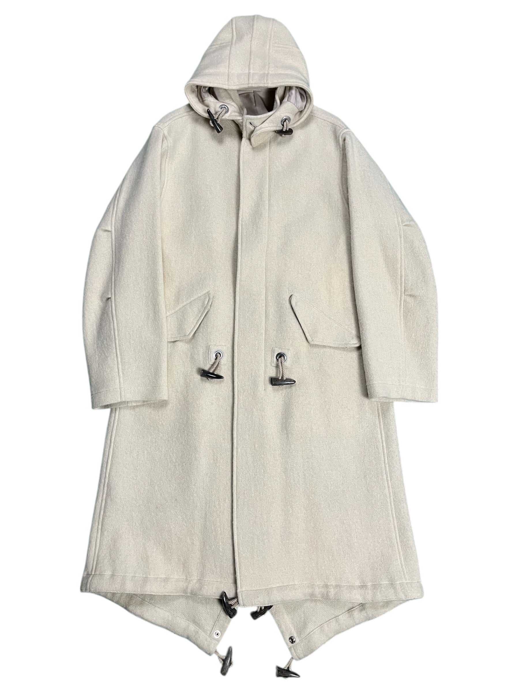 Yohji Yamamoto AW07 runway hooded wool duffel coat hanging on a display, featuring a hood, toggle closures, and a classic duffel design.