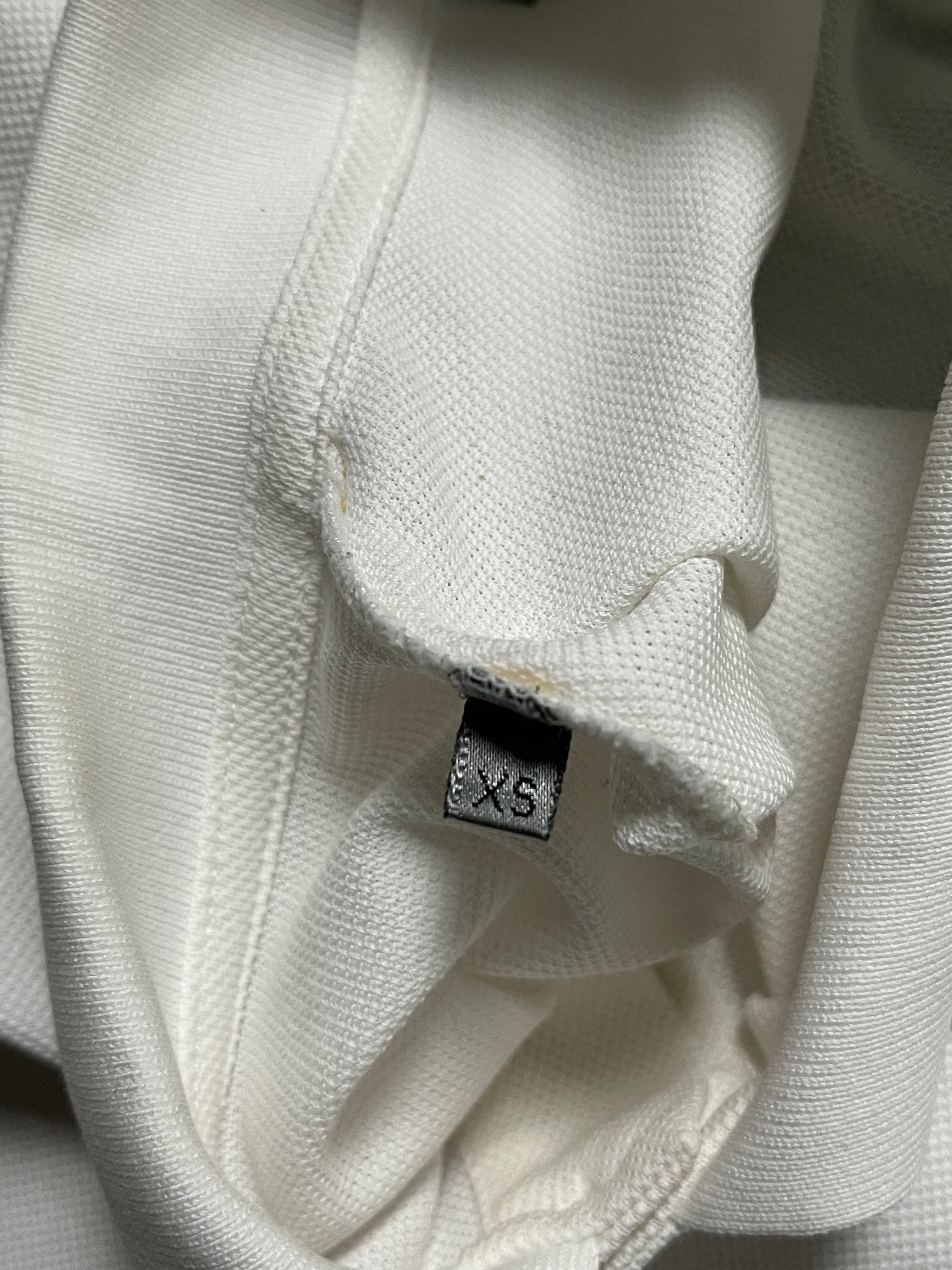Dior SS07 Patch Polo shirt featuring colorful patches on a classic polo style, worn by a model on a white background.