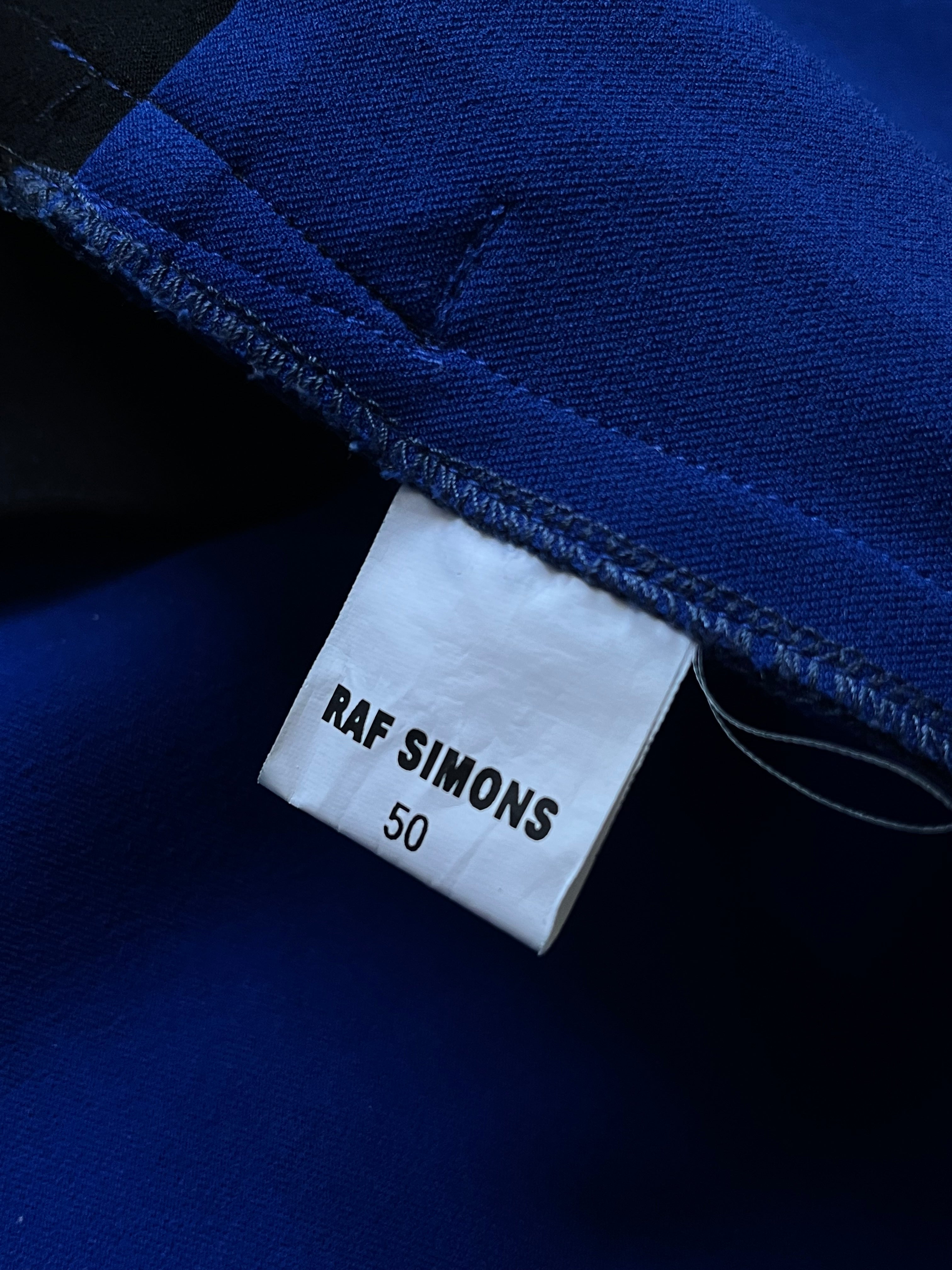 Raf Simons SS14 tri-color athletic long coat with color-block design and tailored fit, displayed on a hanger.