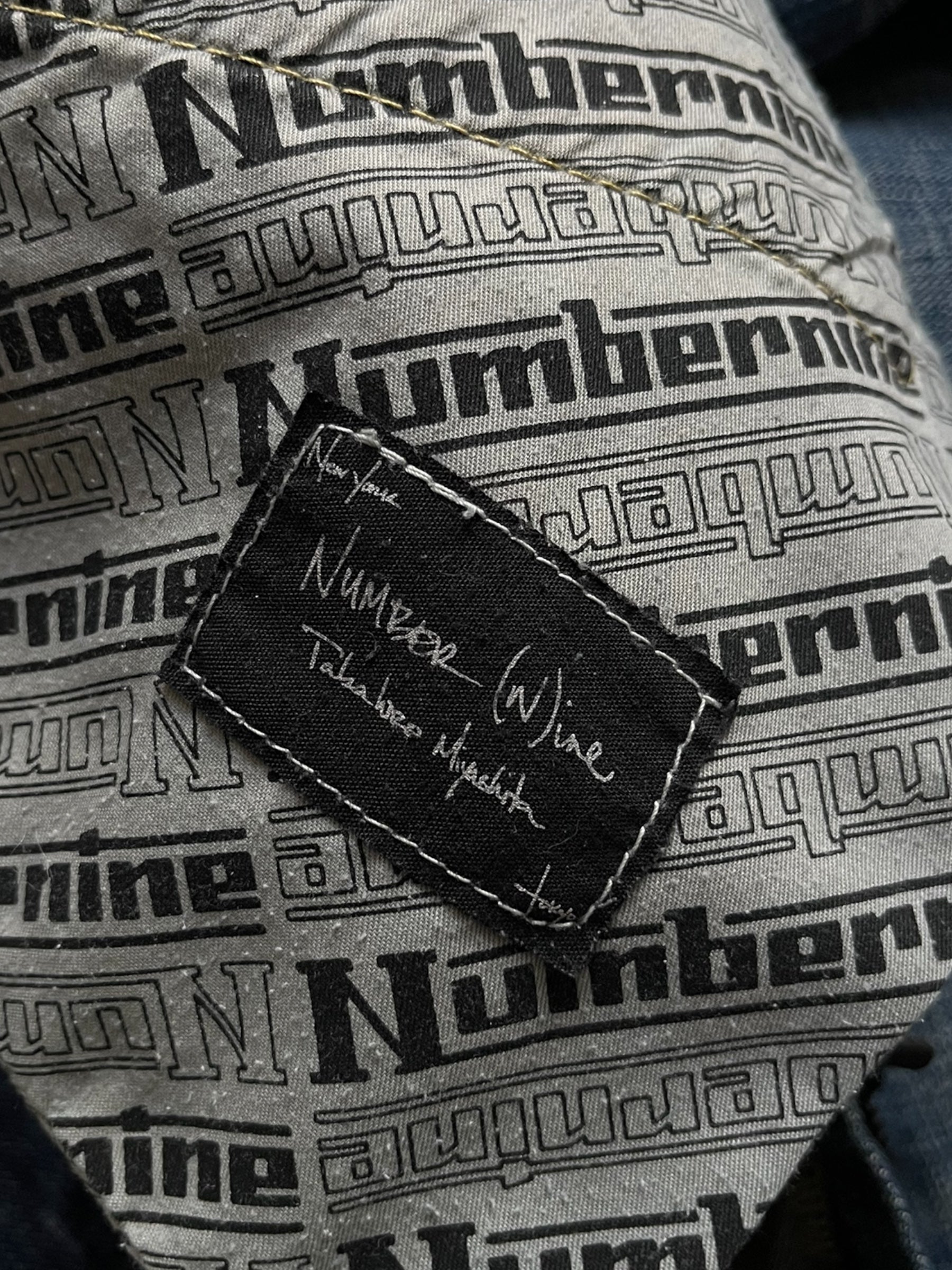 Number (N)ine SS05 “Nightcrawler” distressed denim pants, showing a close-up of ripped and faded denim fabric.
