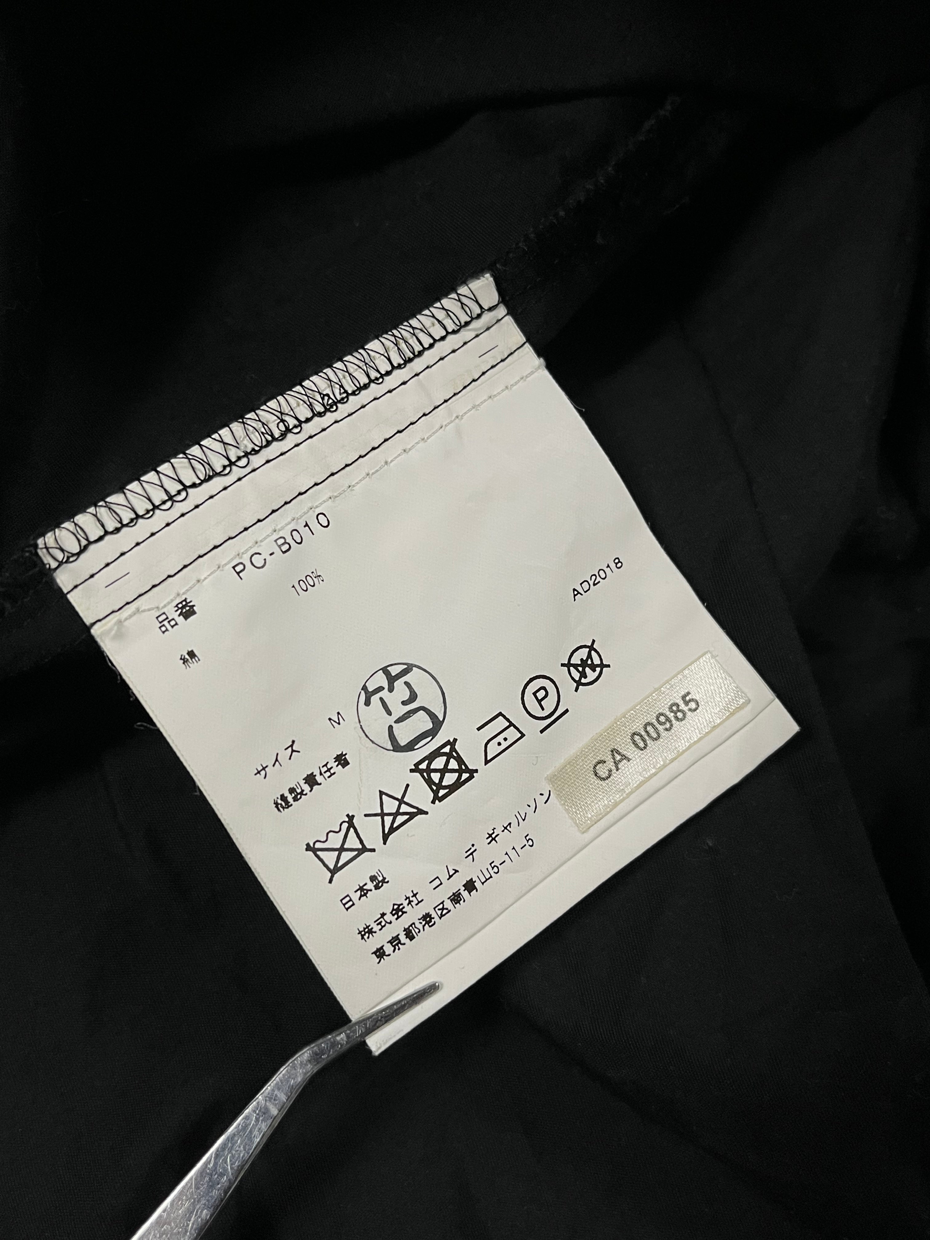 Comme des Garçons Homme Plus SS19 paneled shirt with unique design, shown in a close-up image highlighting fabric and panel details.