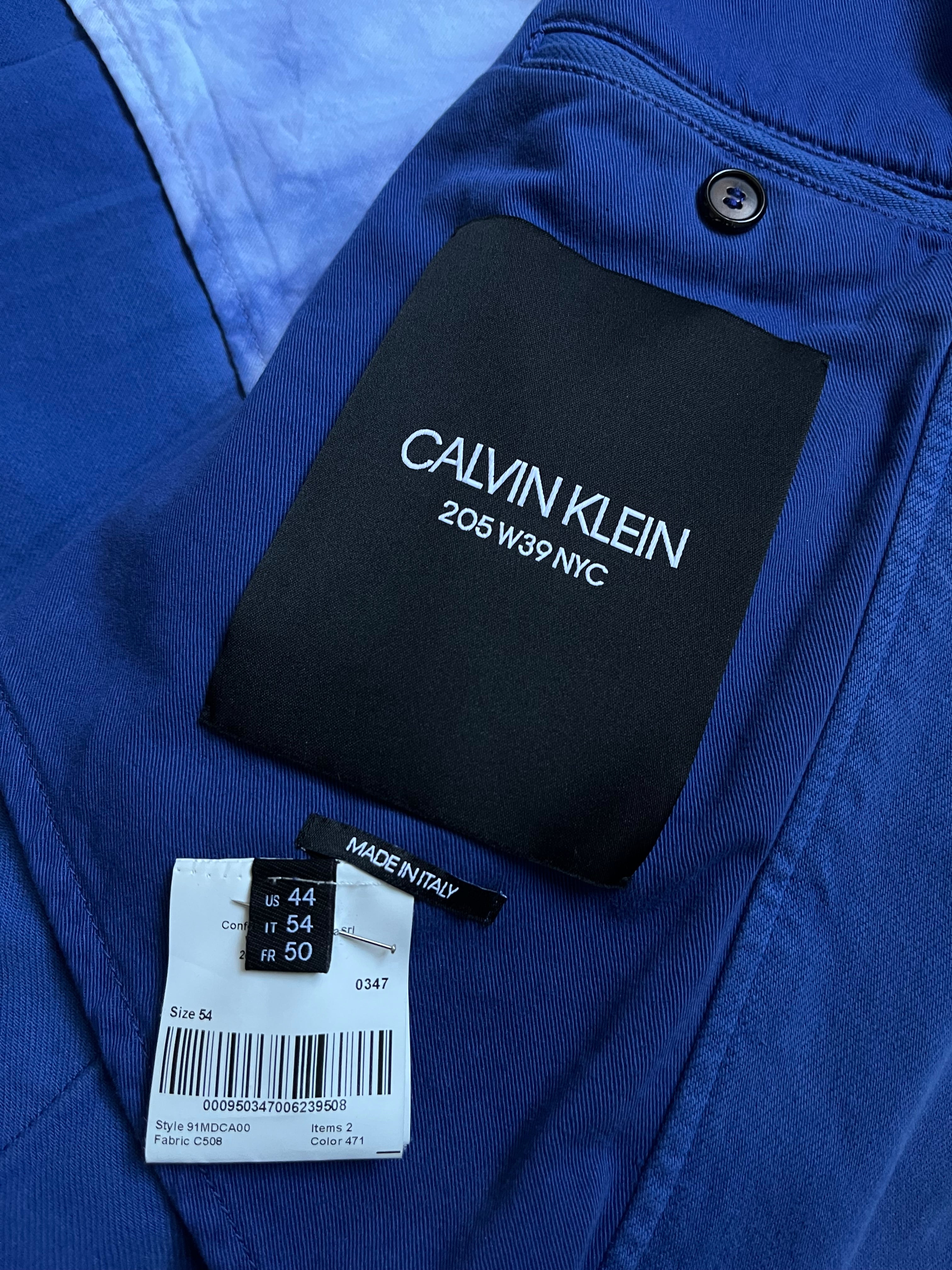 Raf Simons SS19 Calvin Klein 205w39nyc tie-dye overcoat with bold pattern and oversized fit, displayed on a hanger.