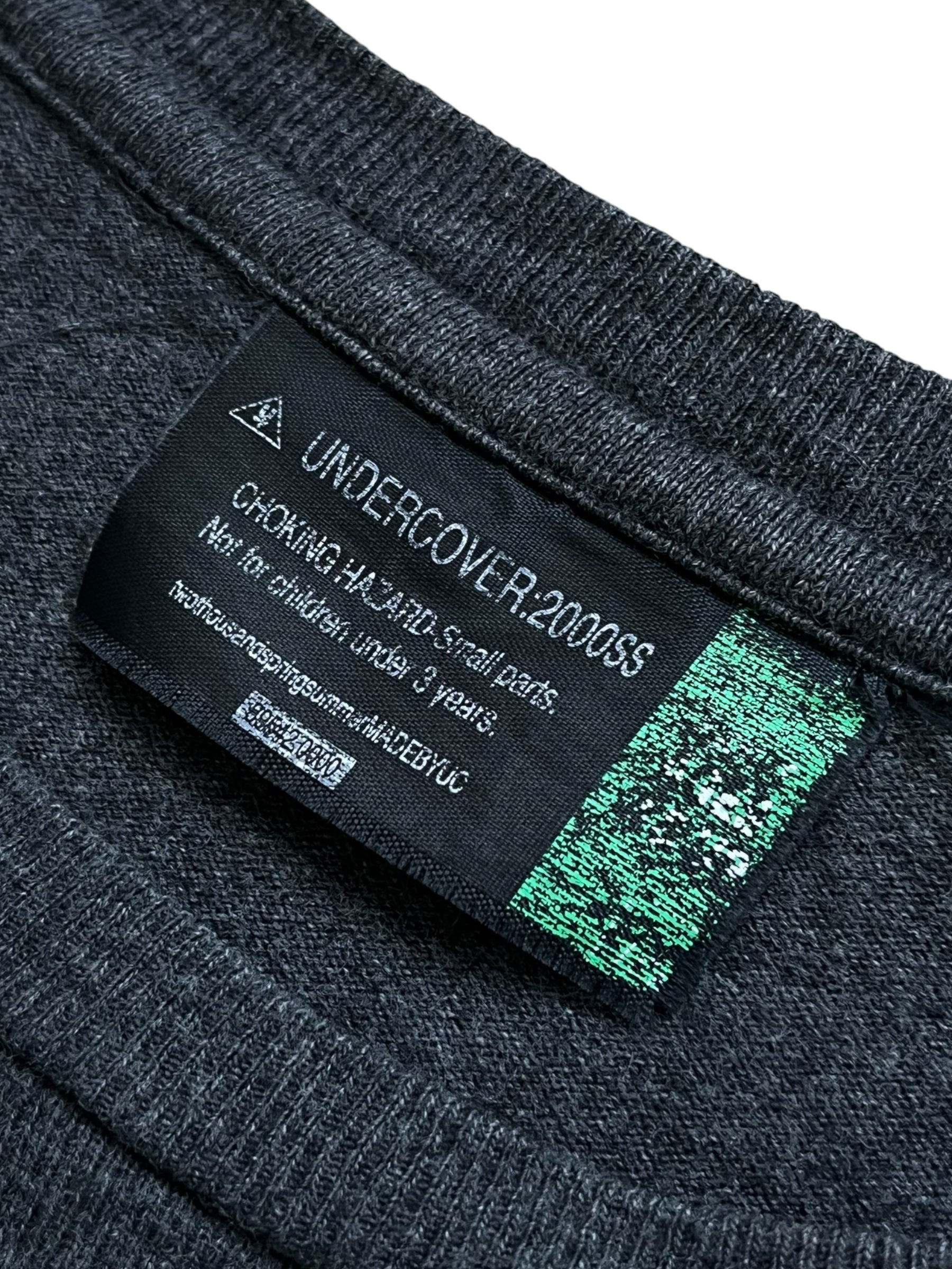 Undercover SS00 "Teaser" WTAPS Generation F*uck You T-shirt displayed on a hanger with bold graphic print in black and white.