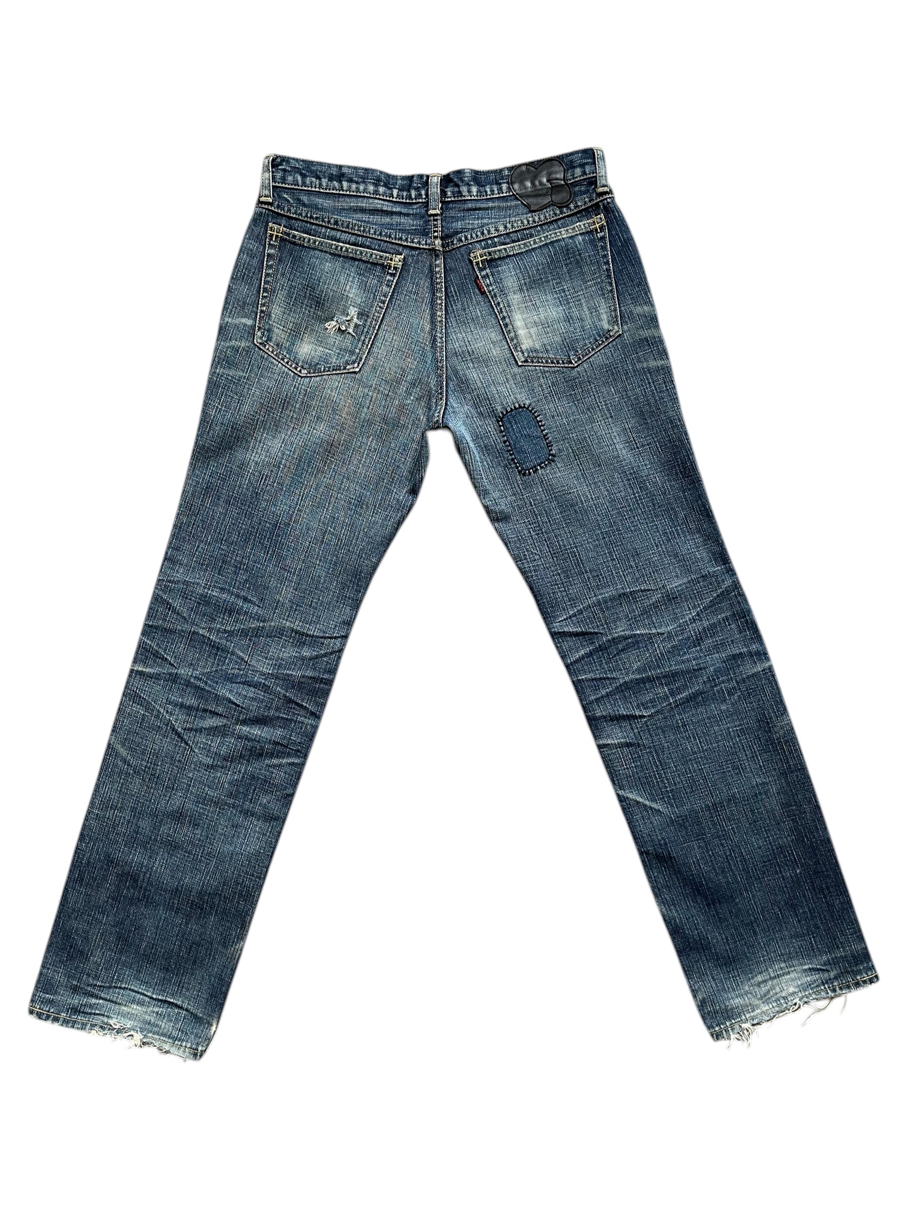 Number (N)ine SS05 Nightcrawler distressed denim pants with ripped details and a slim fit, showcased on a model.