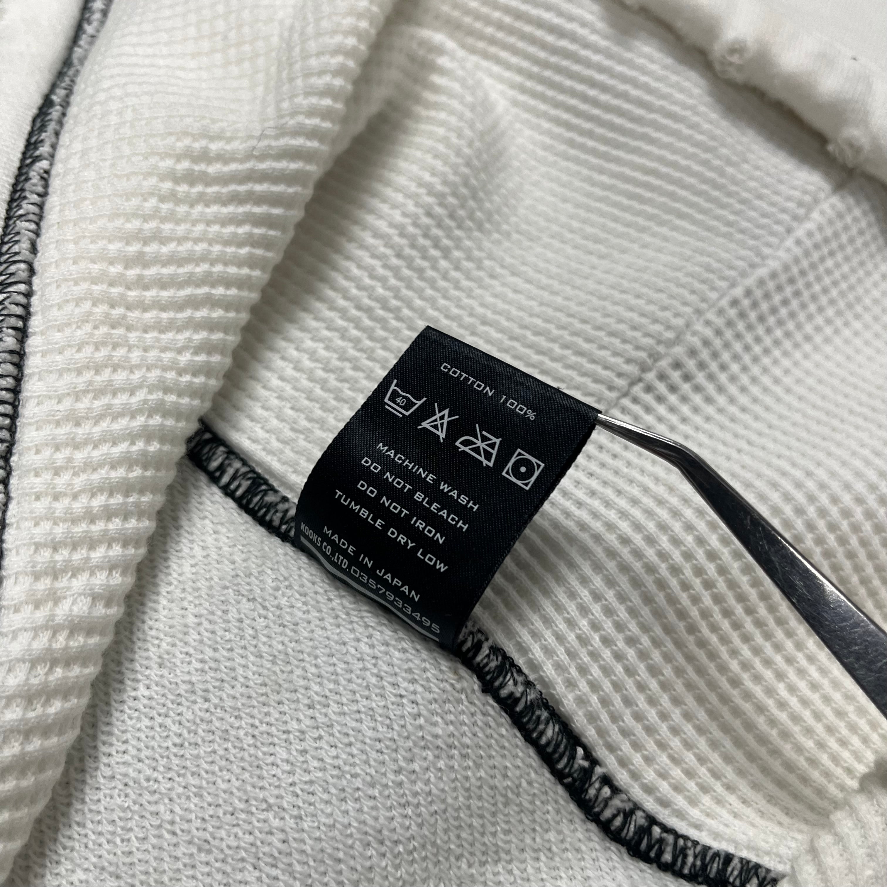 Number (N)ine SS05 Nightcrawler asymmetrical zip-up jacket with unique design and dark fabric, shown in a close-up view.