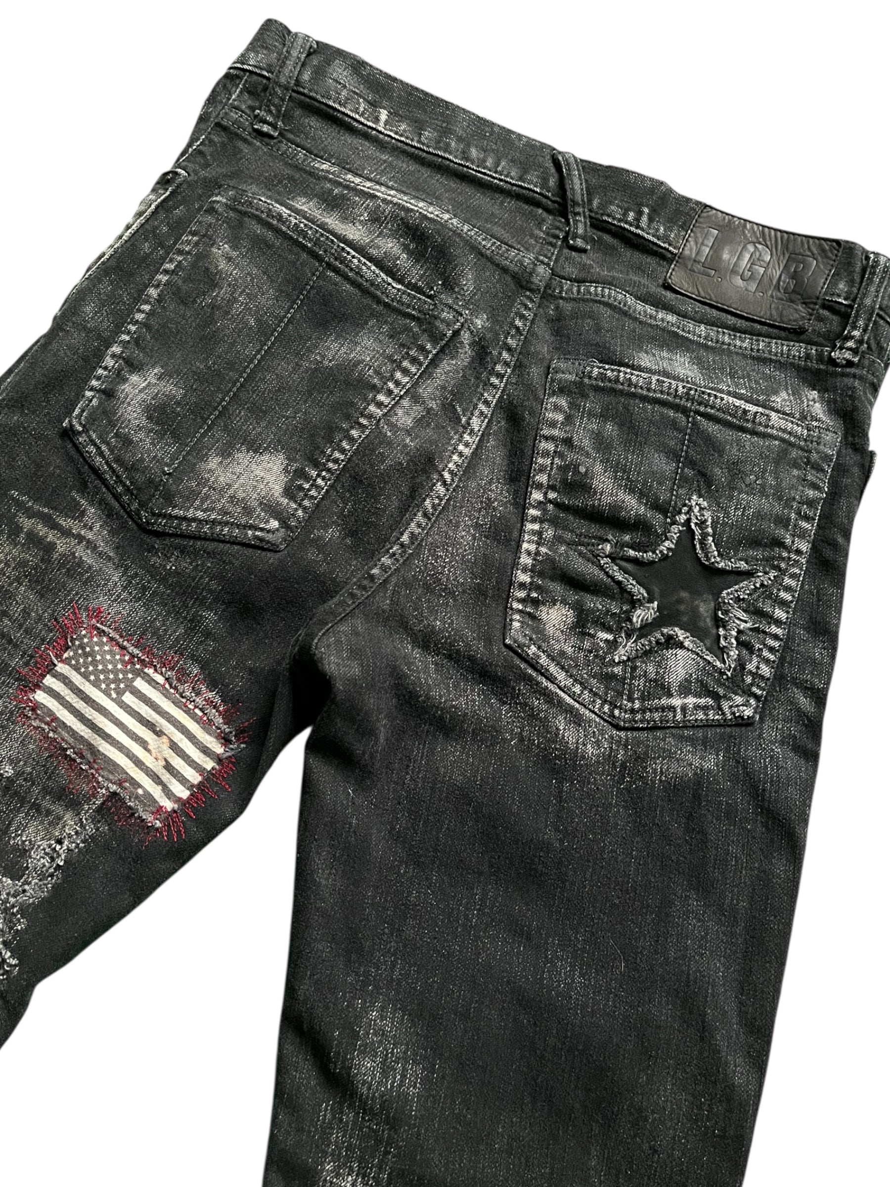 Le Grande Bleu wolf cut waxed distressed denim pants with a vintage 2000s style, featuring a rugged, worn look.