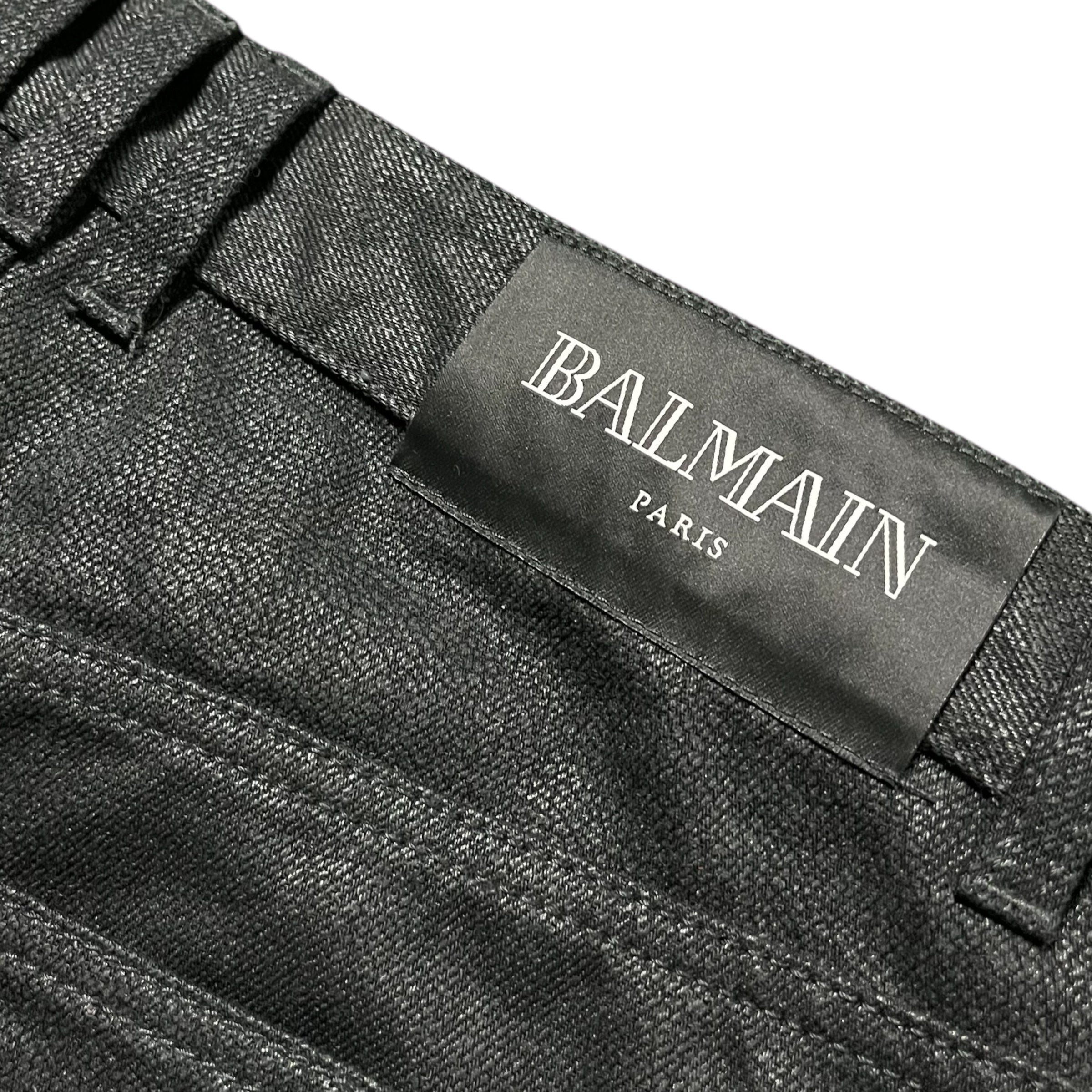 Balmain AW23 Limited Edition waxed denim pants showing distressed detailing and slim fit style.