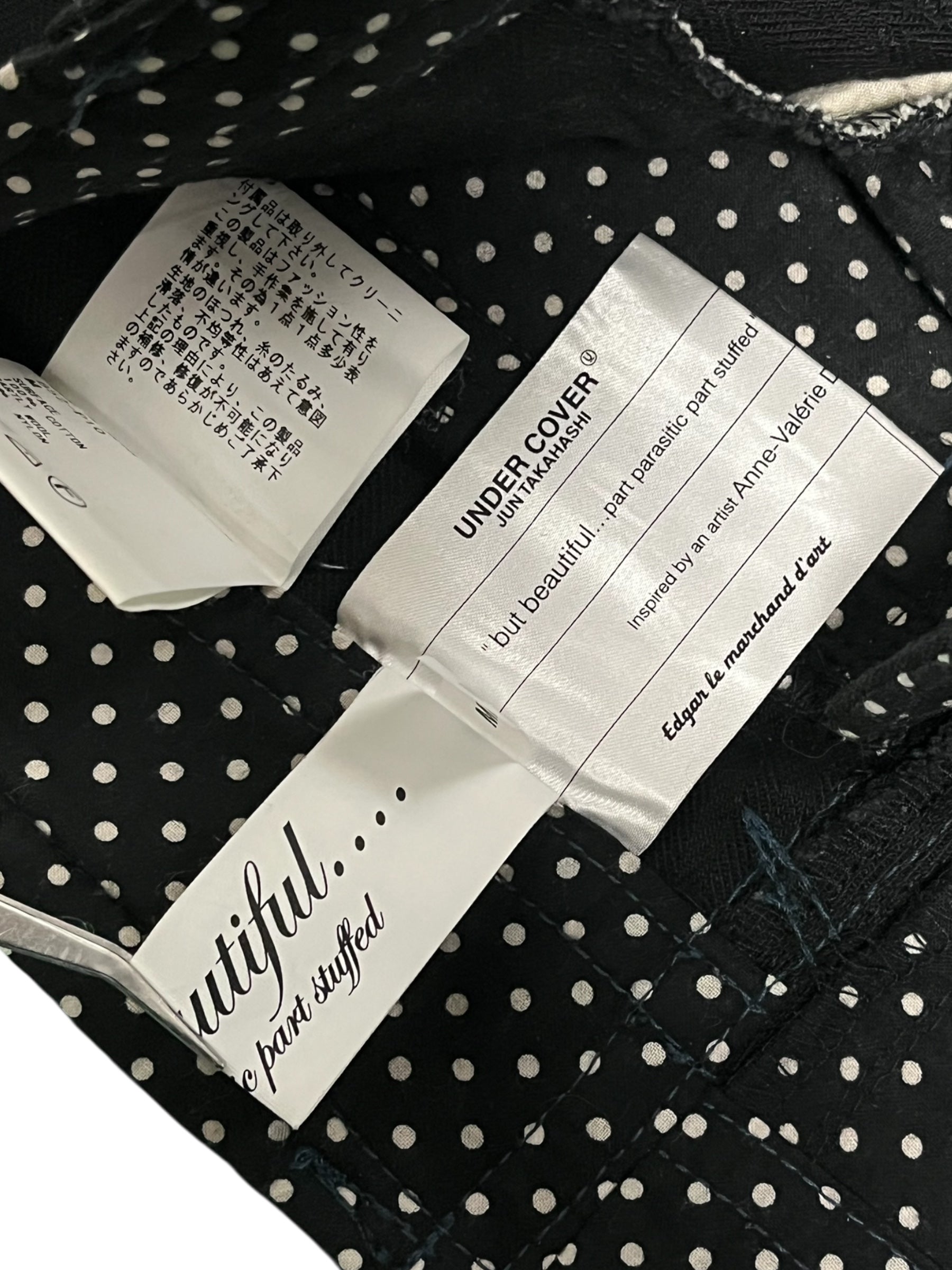 Undercover AW04 "But Beautiful" cargo pants featuring layered parasitic and stuffed design elements, in dark fabric with pockets.