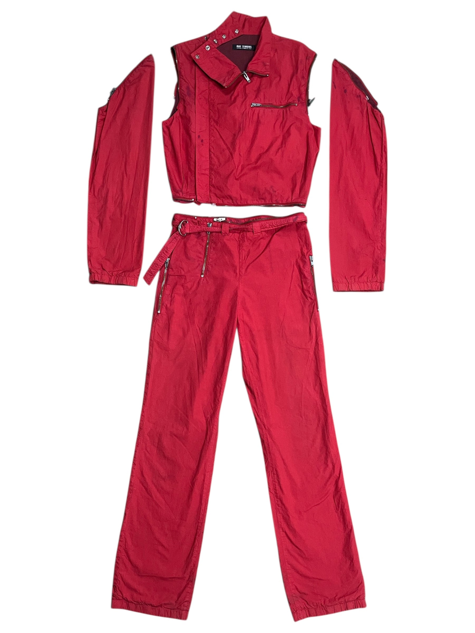 Red Raf Simons SS02 "Woe Onto Those" boiler suit, coverall style with front zipper and utility pockets, shown on a model.