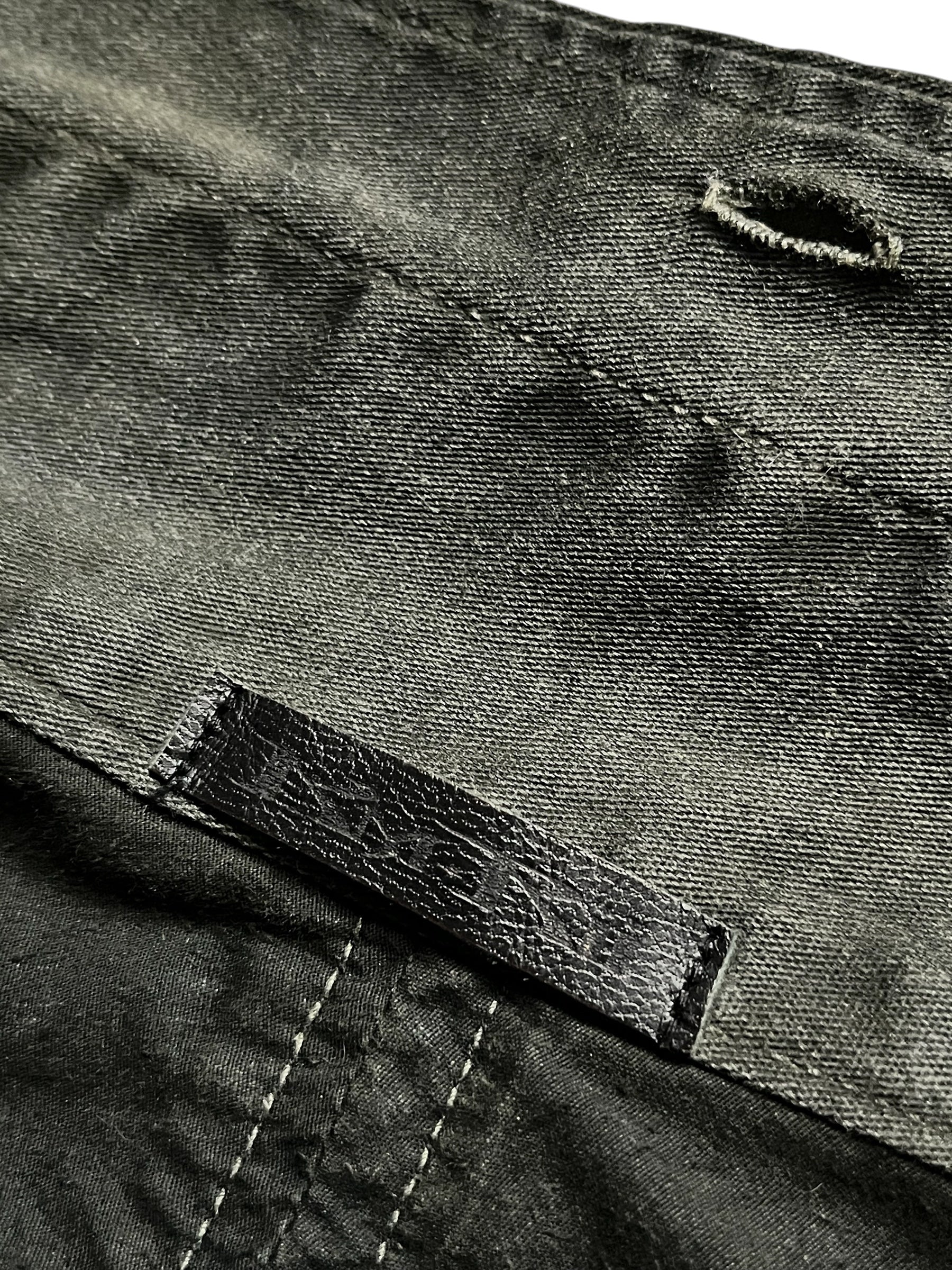 KMRii 00's black shadow military jacket with tactical design, button details, and structured silhouette for a bold, utilitarian look.