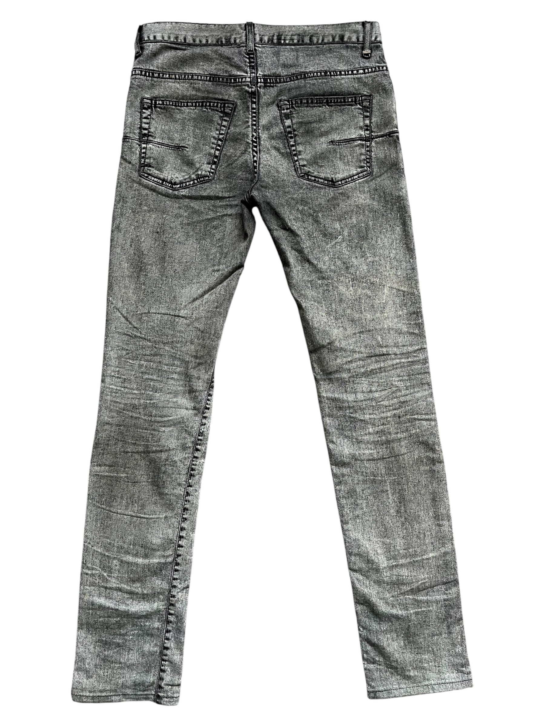 Dior SS15 acid wash slim fit denim pants with classic five-pocket design and distressed details on a model.