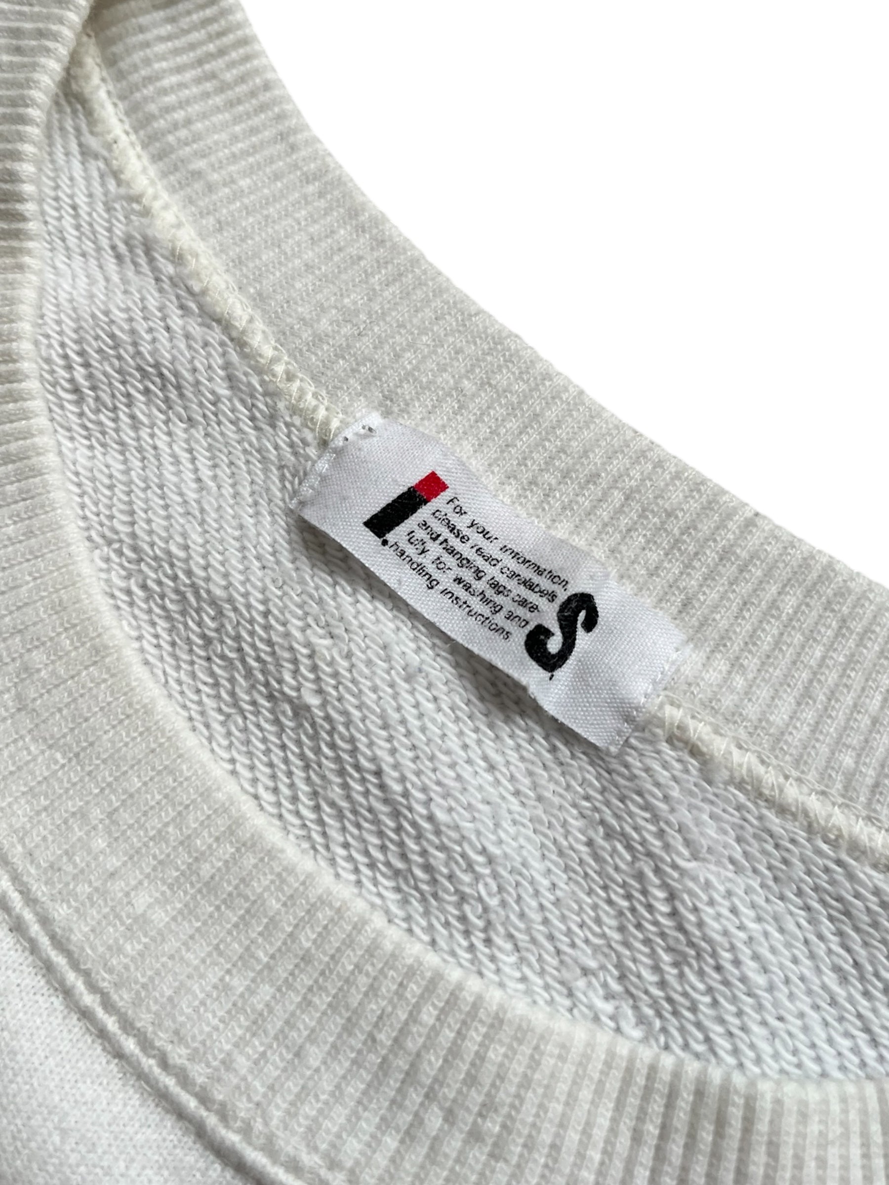 Issey Miyake Tsumori Chisato 80s-inspired crewneck sweater with bold patterns and vibrant colors, displayed on a hanger.