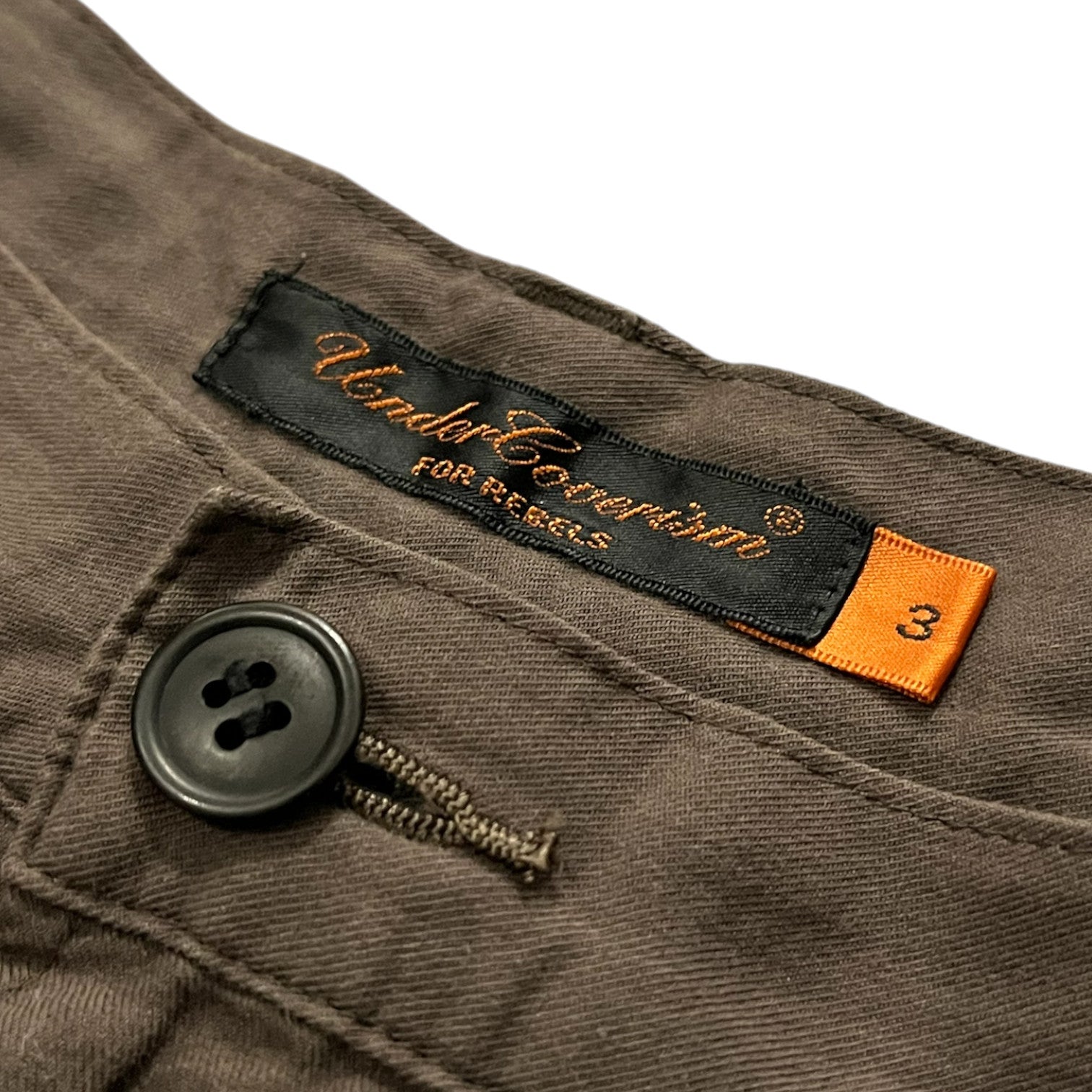 Undercover SS06 “T” military cargo pants in durable fabric, featuring multiple pockets and a relaxed fit.