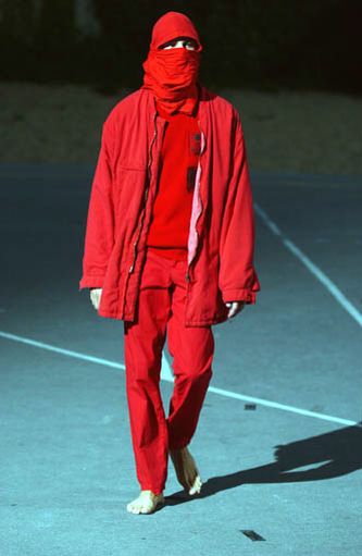 Red Raf Simons SS02 "Woe Onto Those" boiler suit, coverall with a bold, structured design, shown on a model.
